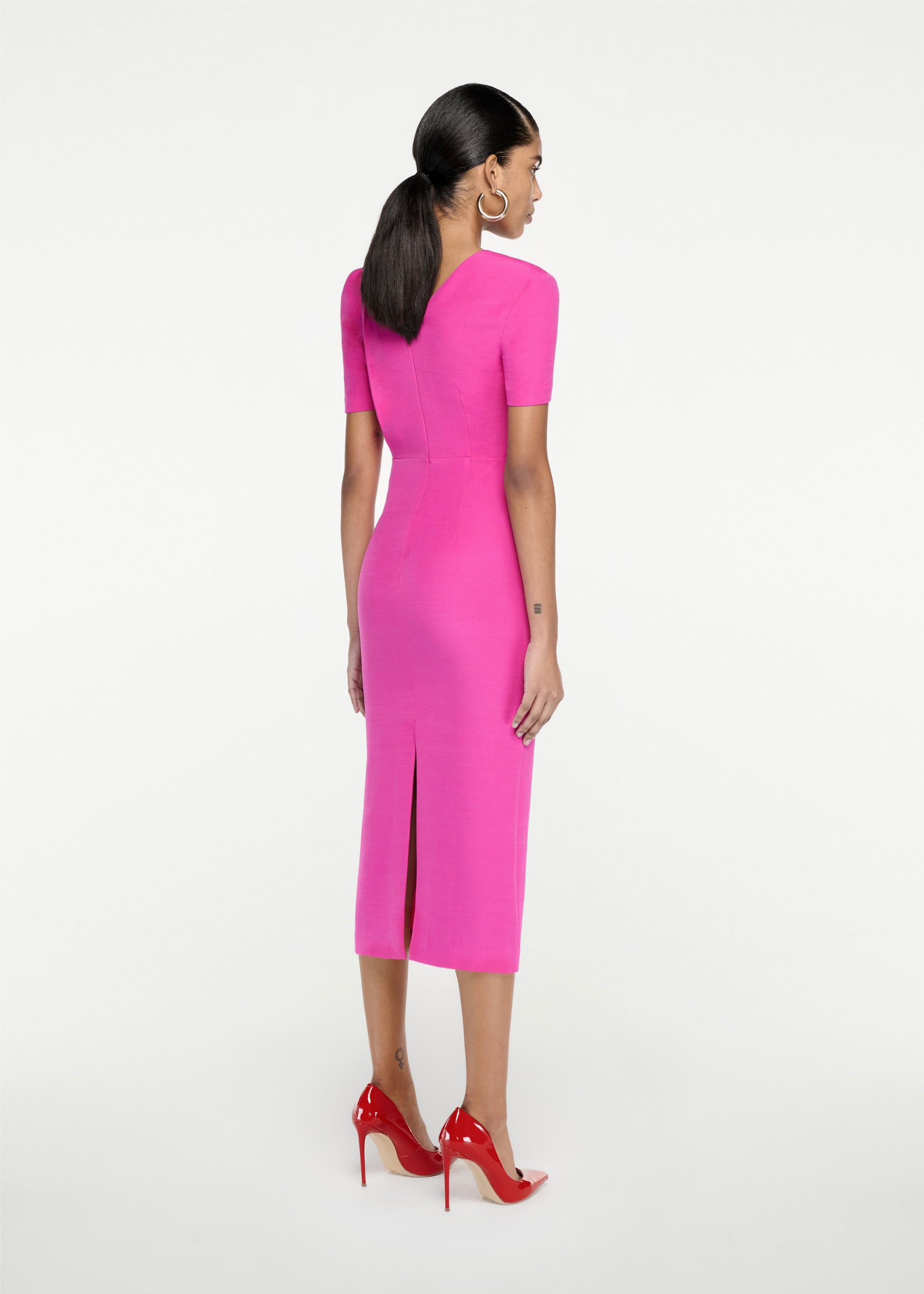The back of a woman wearing the Short Sleeve Silk Wool Midi Dress in Pink