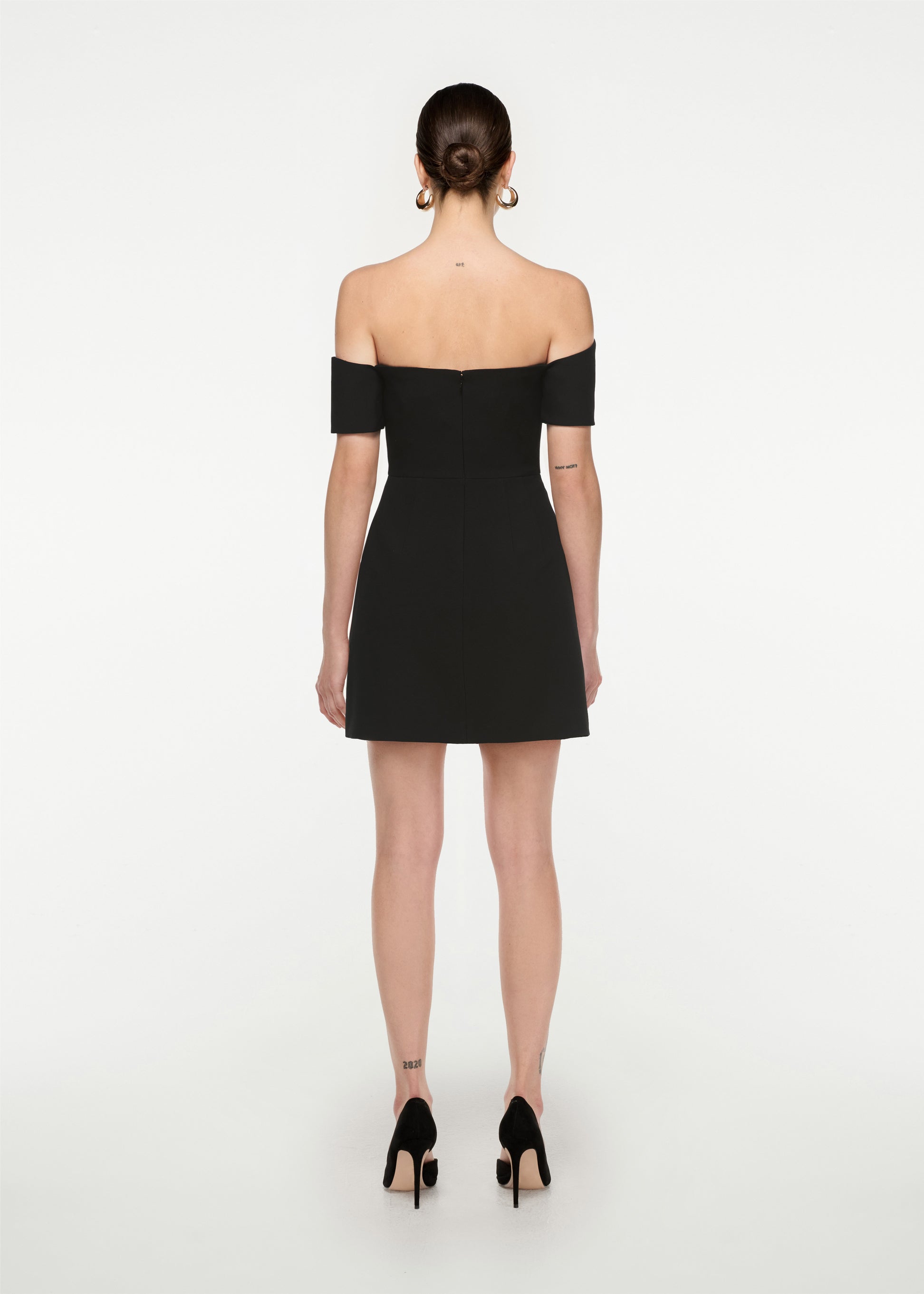 The back of a woman wearing the Asymmetric Silk Wool  Mini Dress in Black