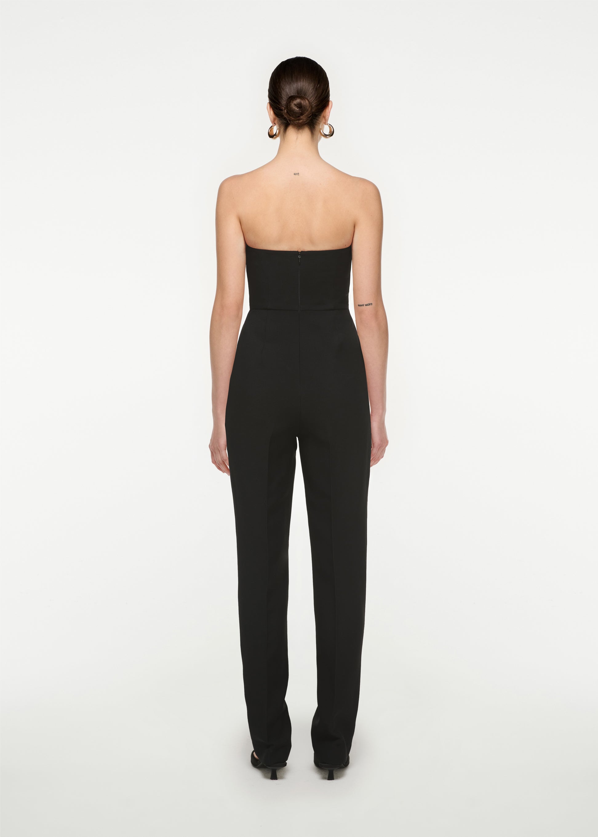 The back of a woman wearing the Strapless Silk Wool Diamante Jumpsuit in Black