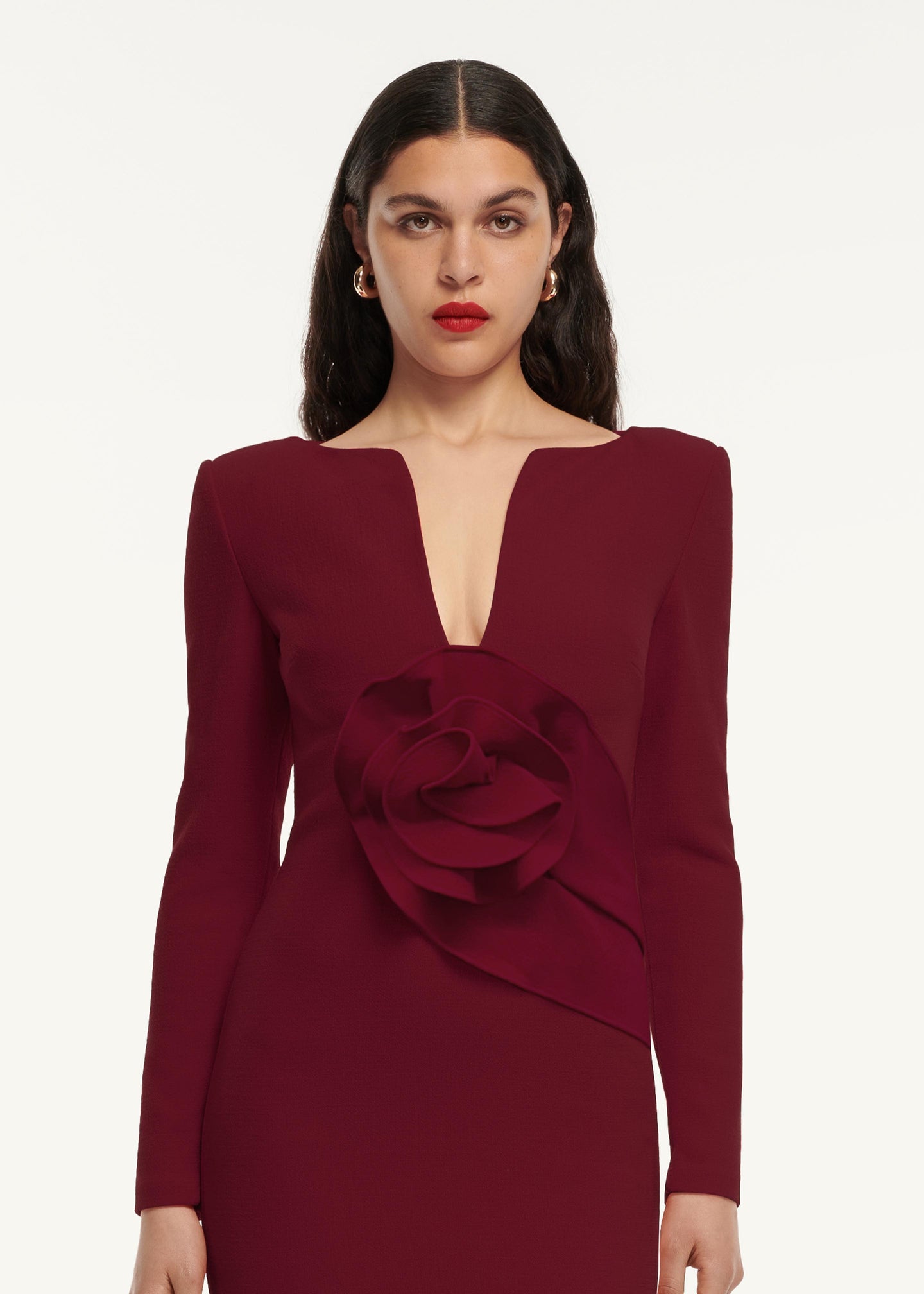 A close up image of a model wearing the Flower Detail Midi Dress in Maroon