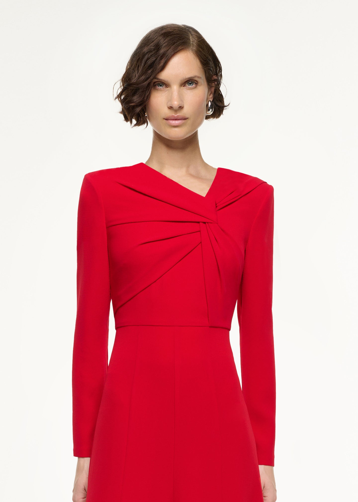 Close up of a model wearing the Long Sleeve Light Cady Midi Dress in Red