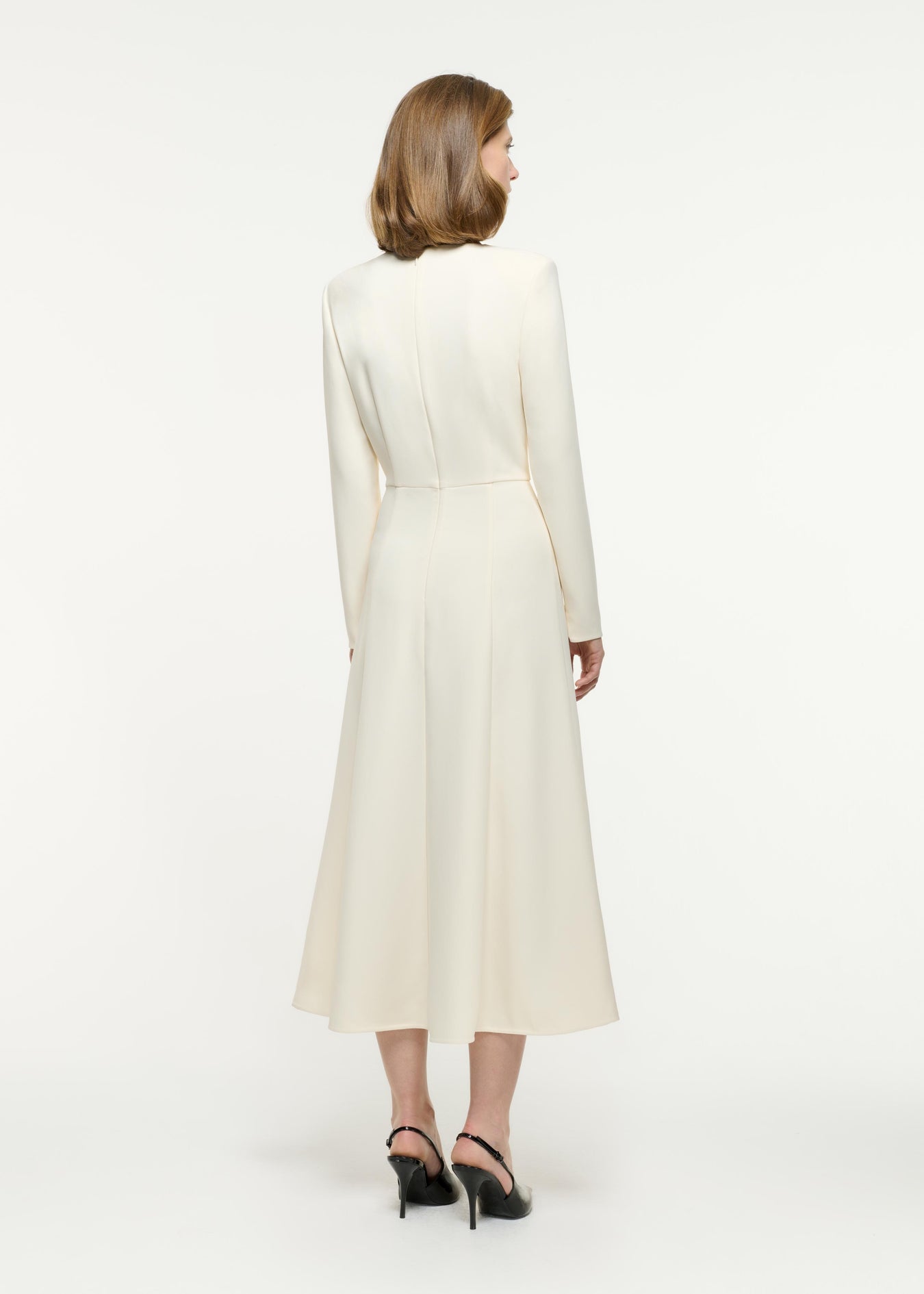 Back view of a model wearing the Long Sleeve Buckle Heavy cady Midi Dress in Cream