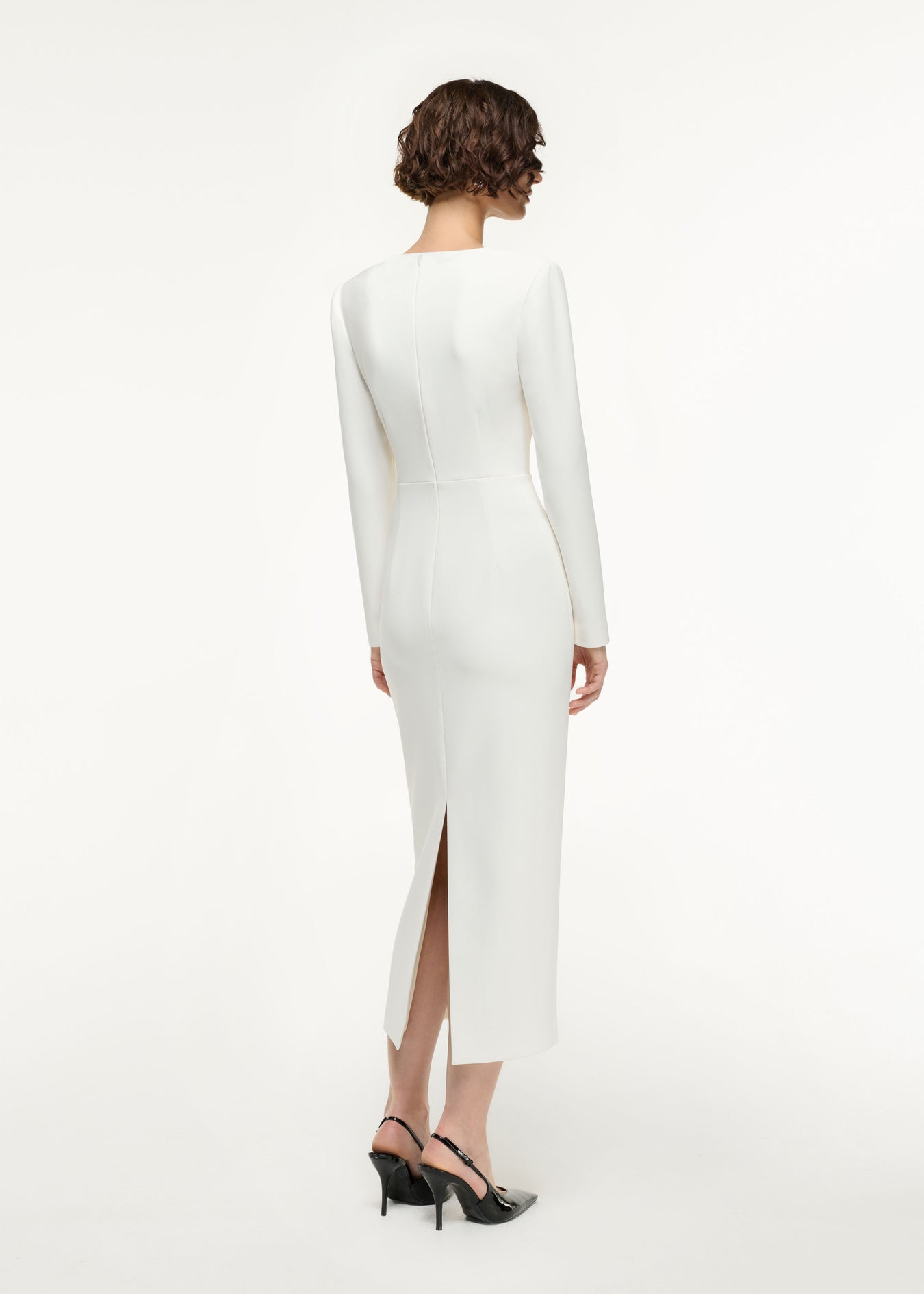 Back view of a model wearing the Long Sleeve Buckle Crepe Midi Dress in Cream