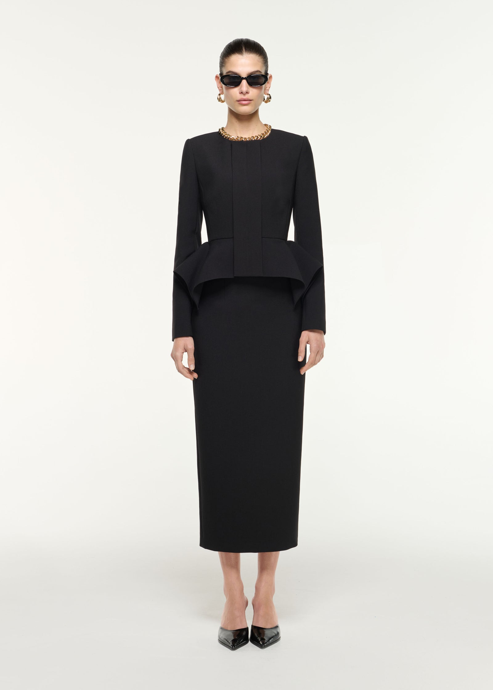 Front view of a model wearing the Crepe Midi Skirt in Black