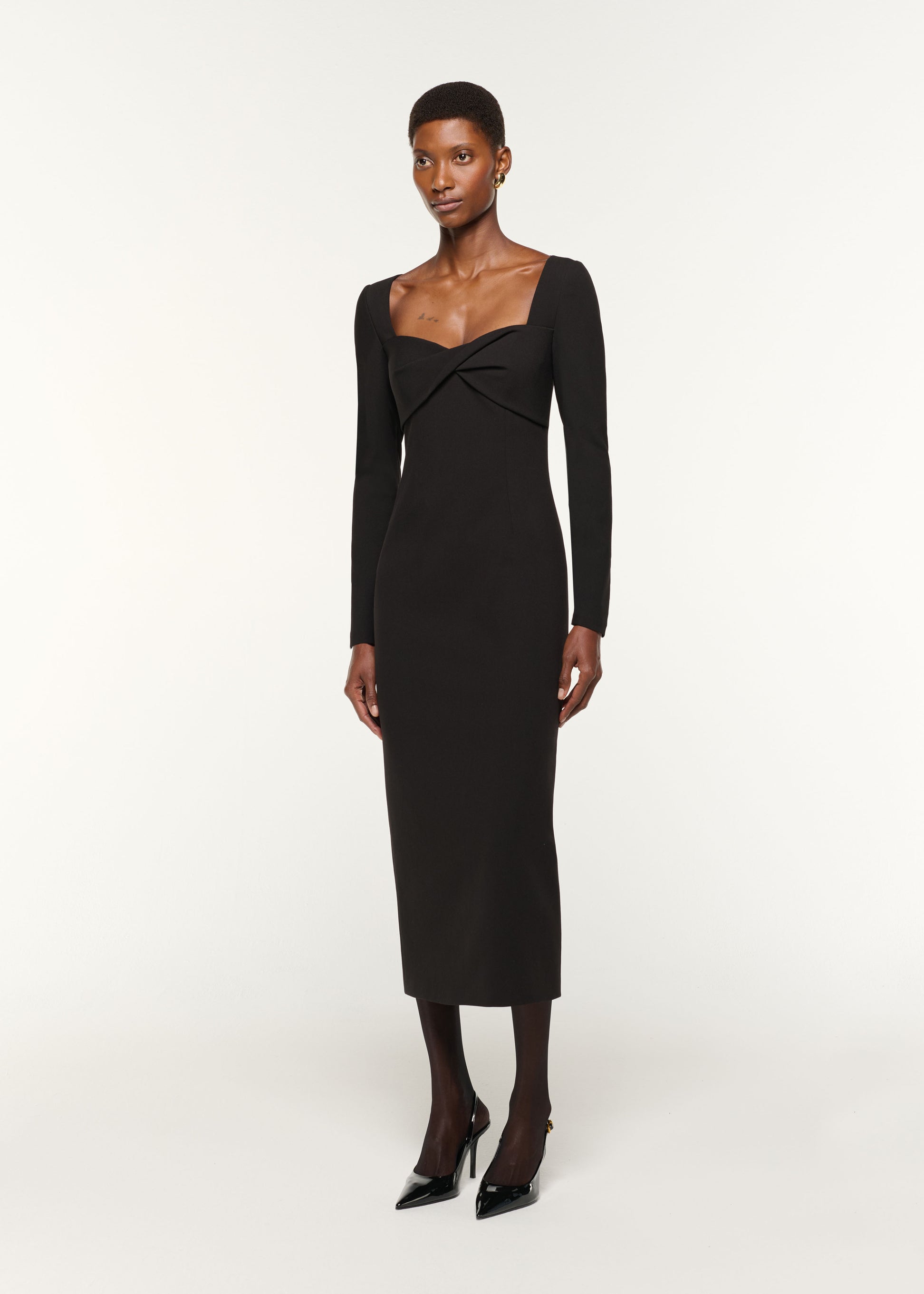 Side view of a model wearing the Twist Drape Stretch Crepe Dress in Black