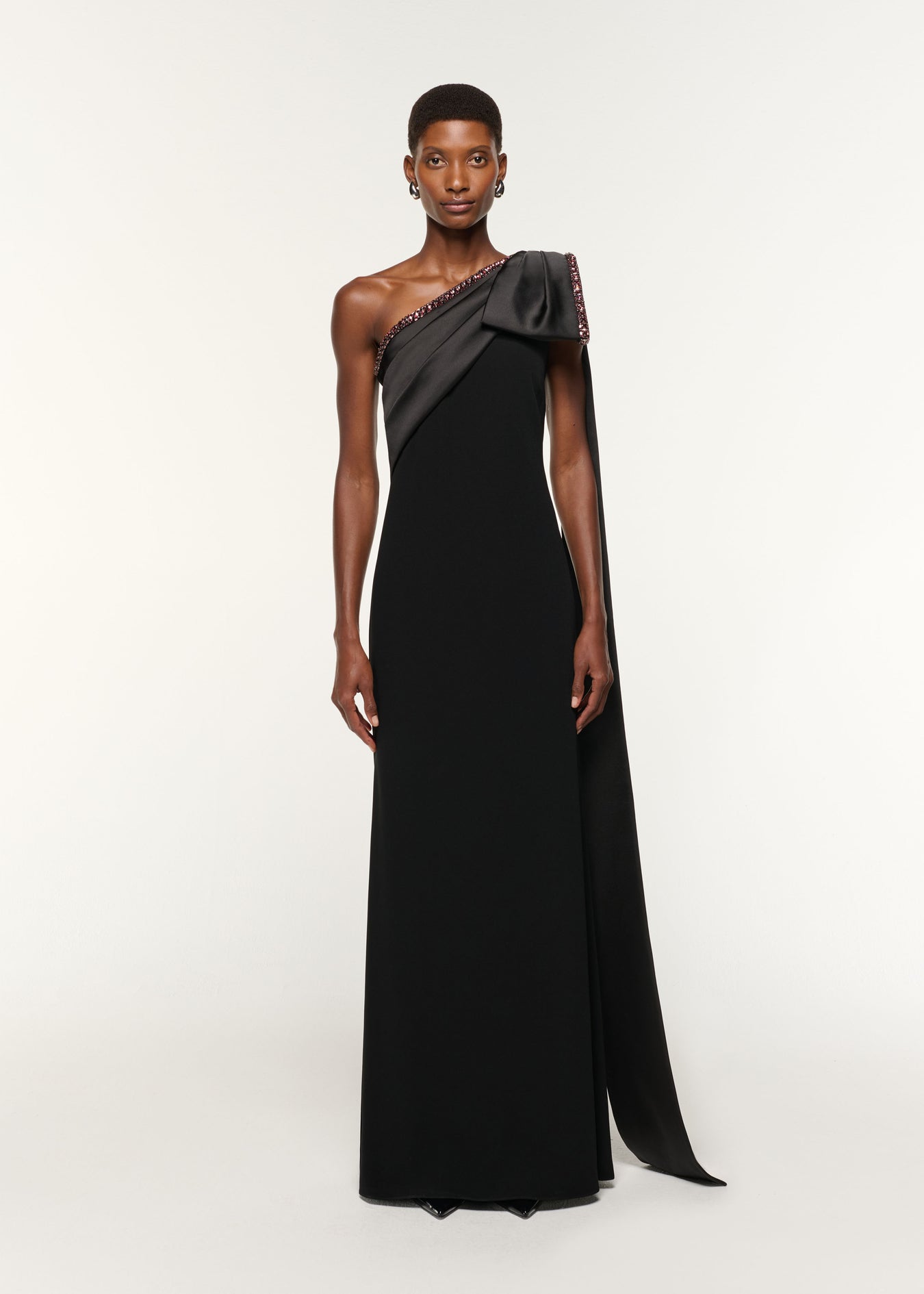 Front view of a model wearing the Contrast Crystal Trimmed Bow Satin Crepe Gown in Black