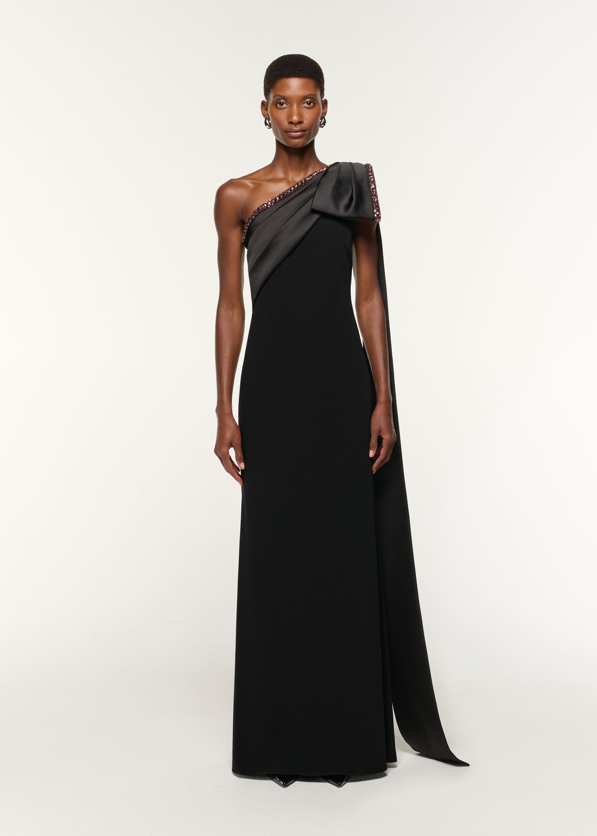 Front view of a model wearing the Contrast Crystal Trimmed Bow Satin Crepe Gown in Black