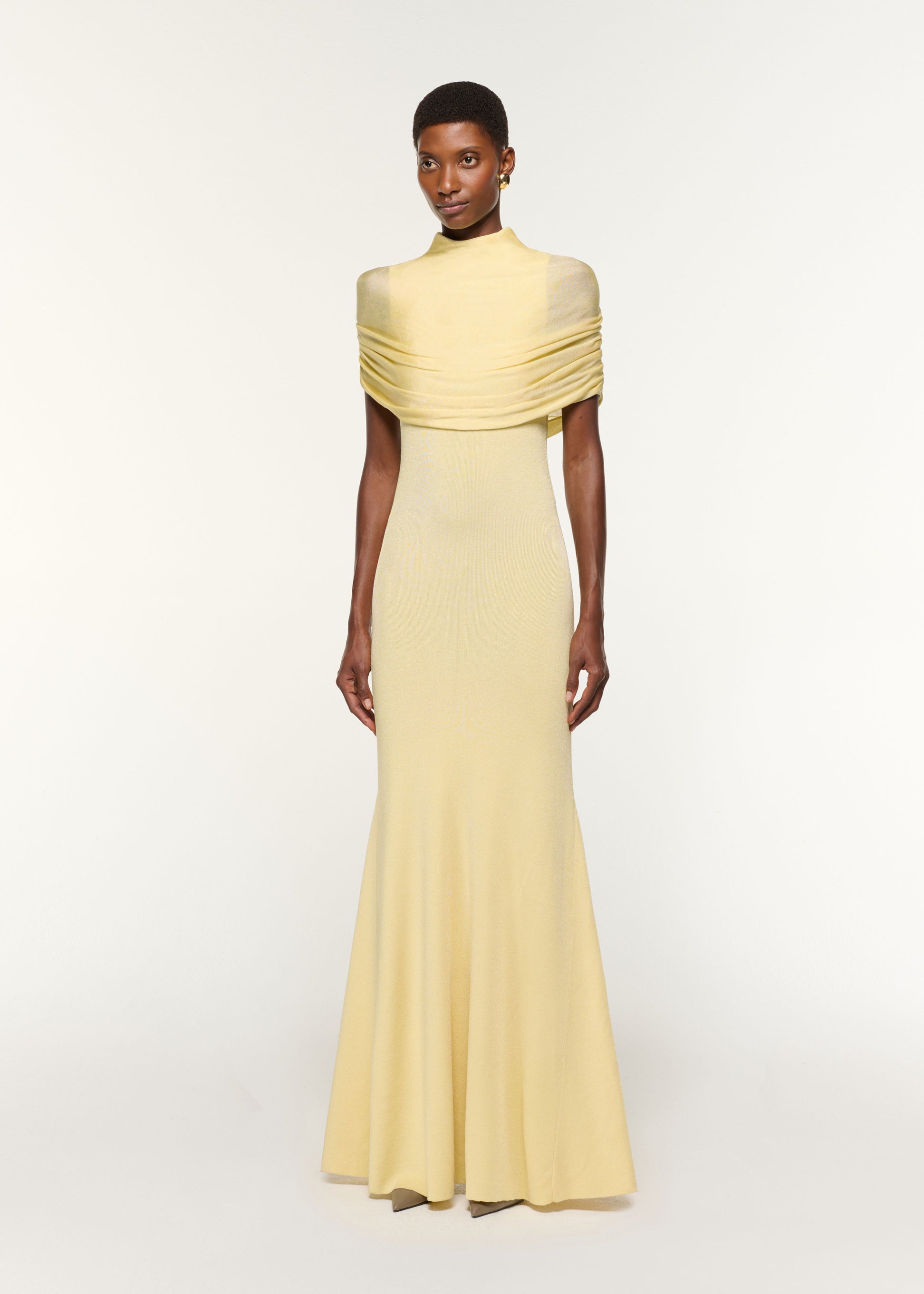 Side view of a model wearing the Draped Shawl Viscose Knit Dress in Yellow