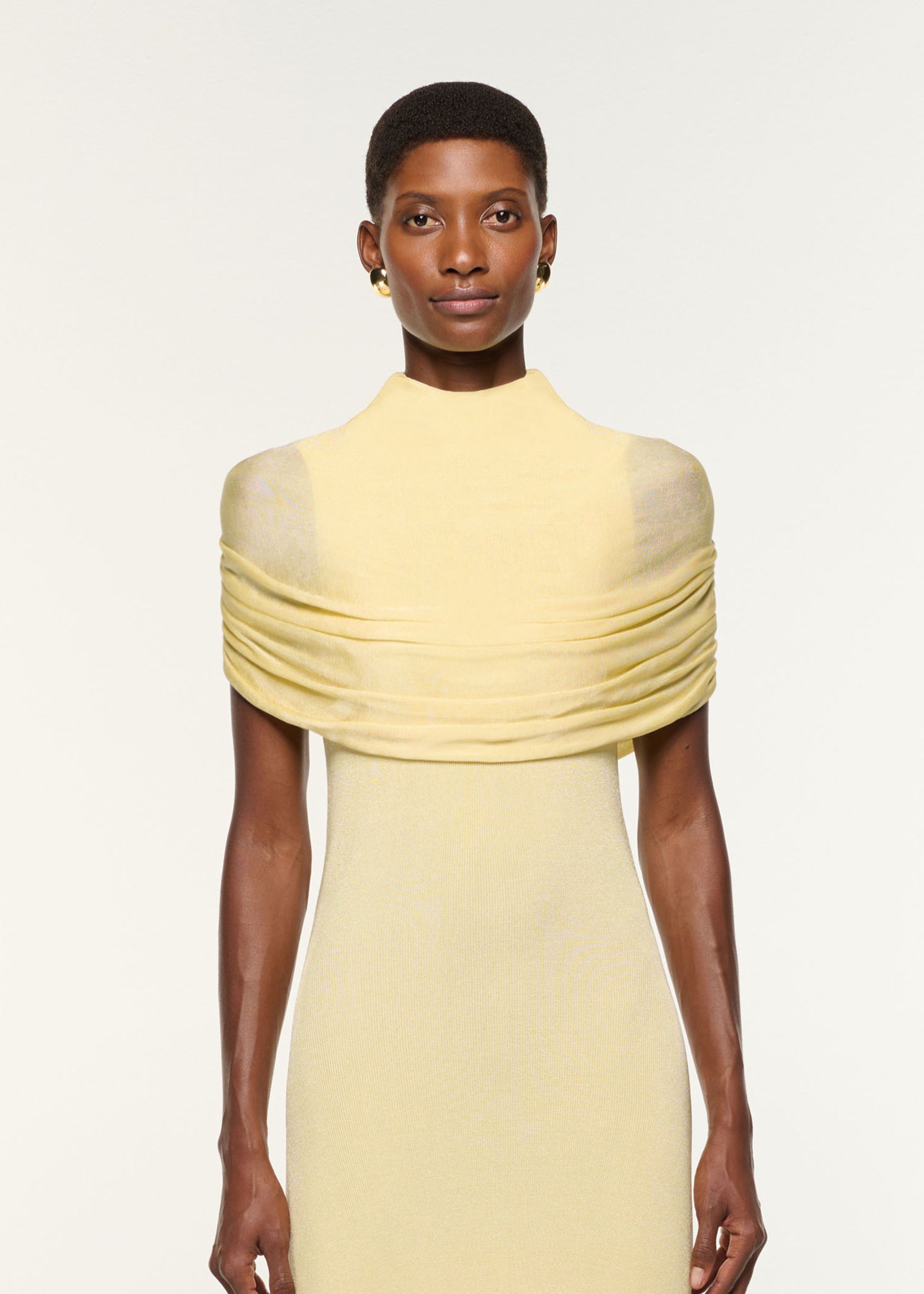 Close up of a model wearing the Draped Shawl Viscose Knit Dress in Yellow