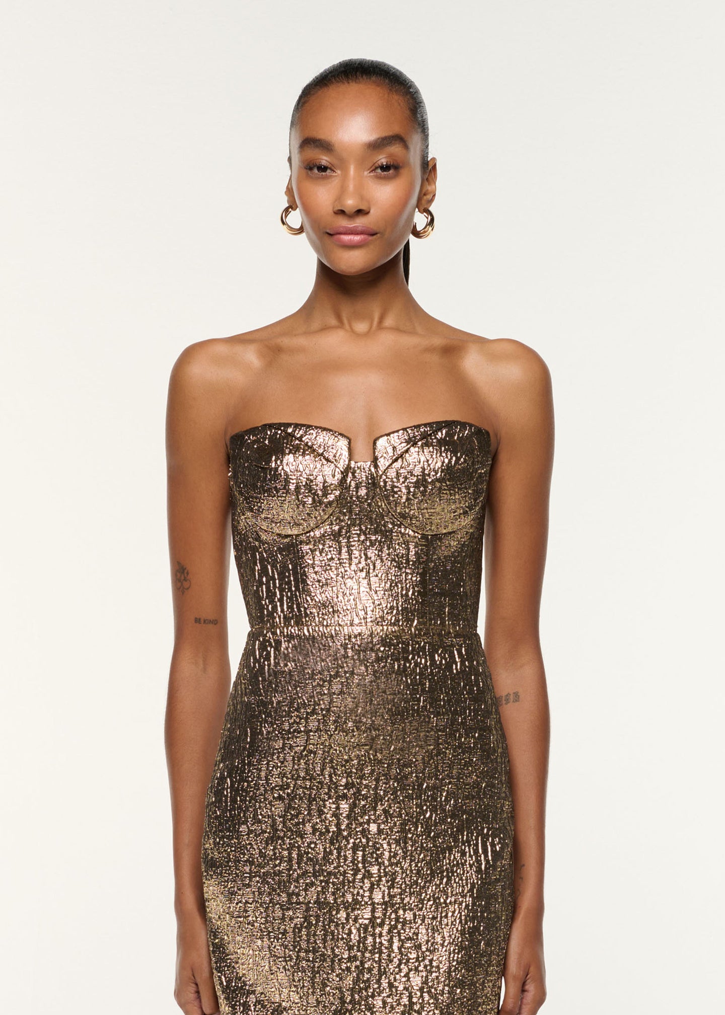 Close up of a model wearing the Pleated Bust Metallic Jacquard Gown in Gold