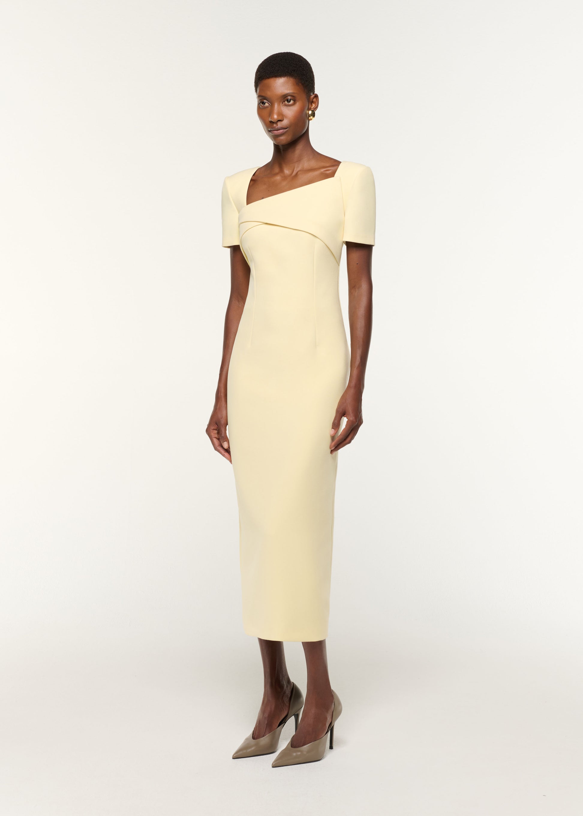 Side view of a model wearing the Asymmetric Drape Crepe Dress in Yellow