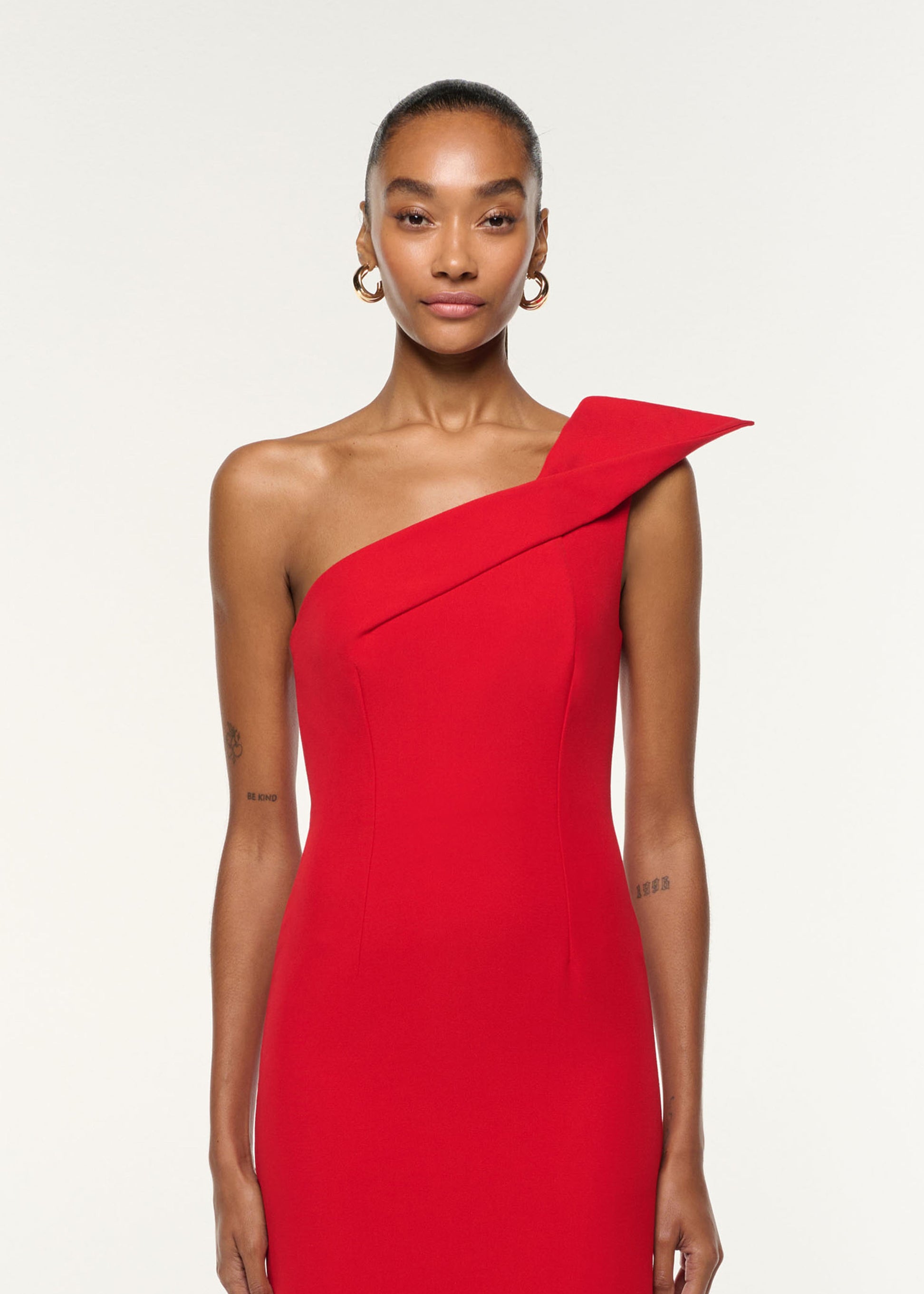 Close up of a model wearing the Structured Drape One Shoulder Crepe Gown in Red