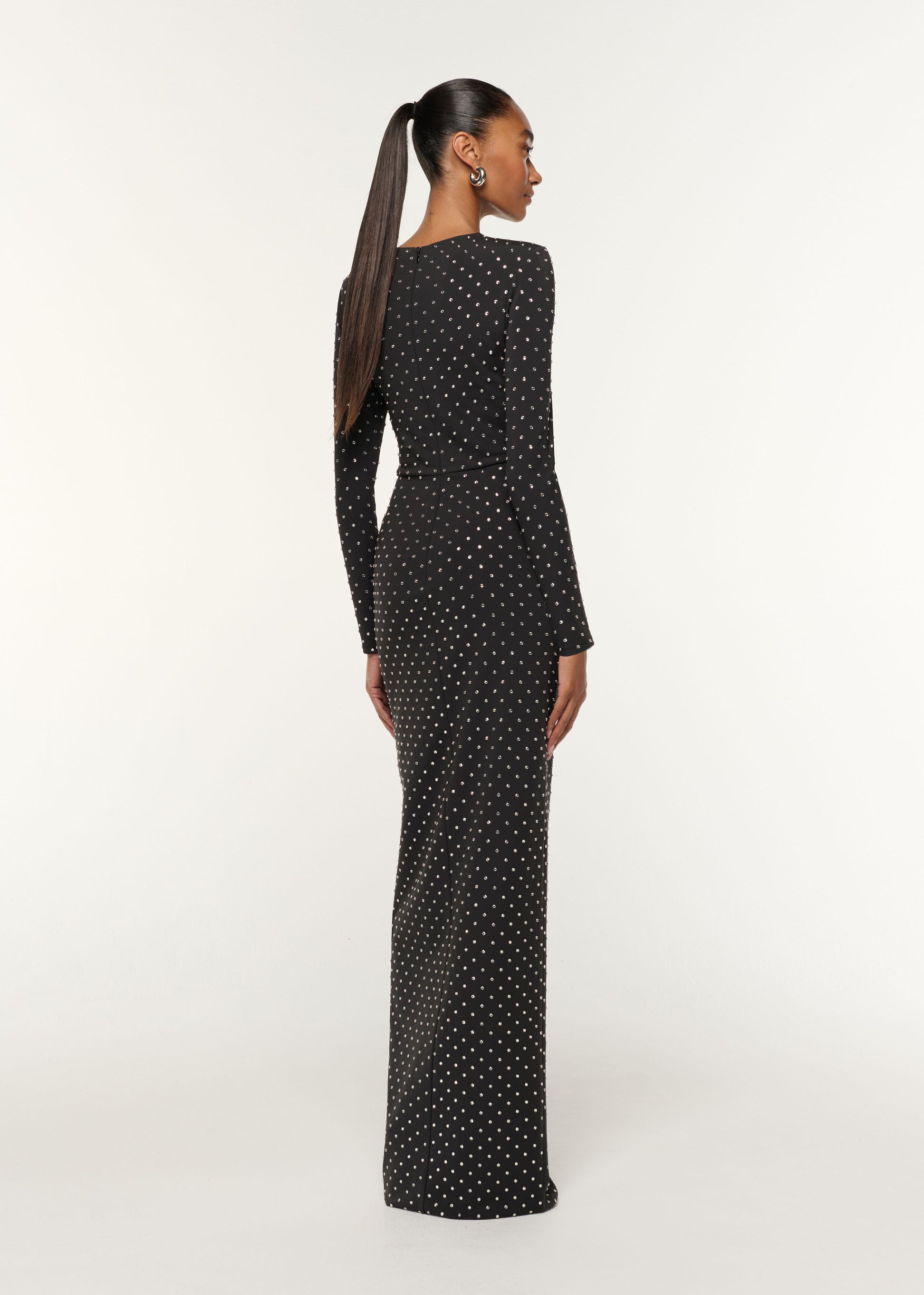 Back view of a model wearing the Jersey Diamante Drape And Metal Trim Gown in Black