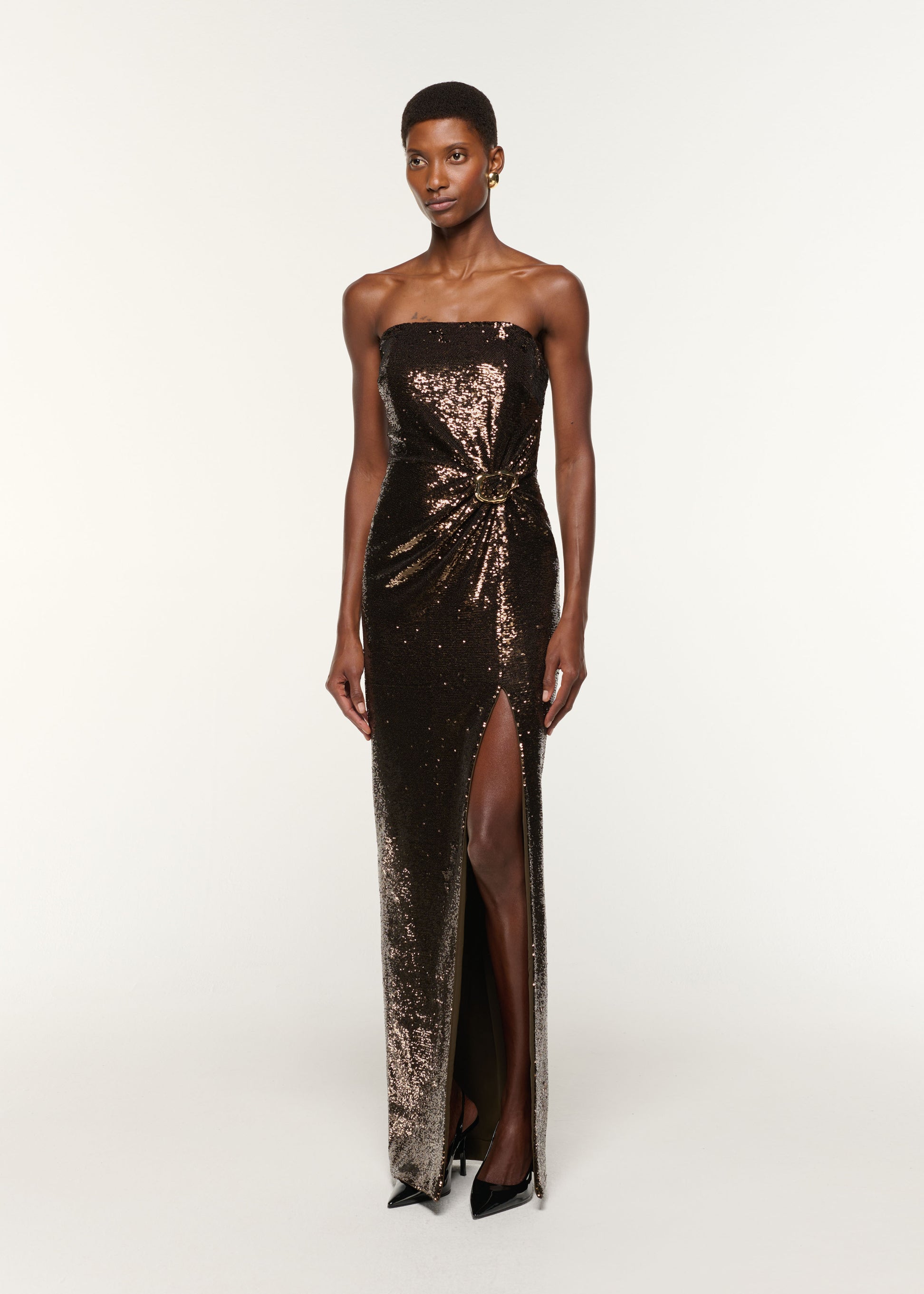 Side view of a model wearing the Strapless Sequin Buckle Gown in Bronze
