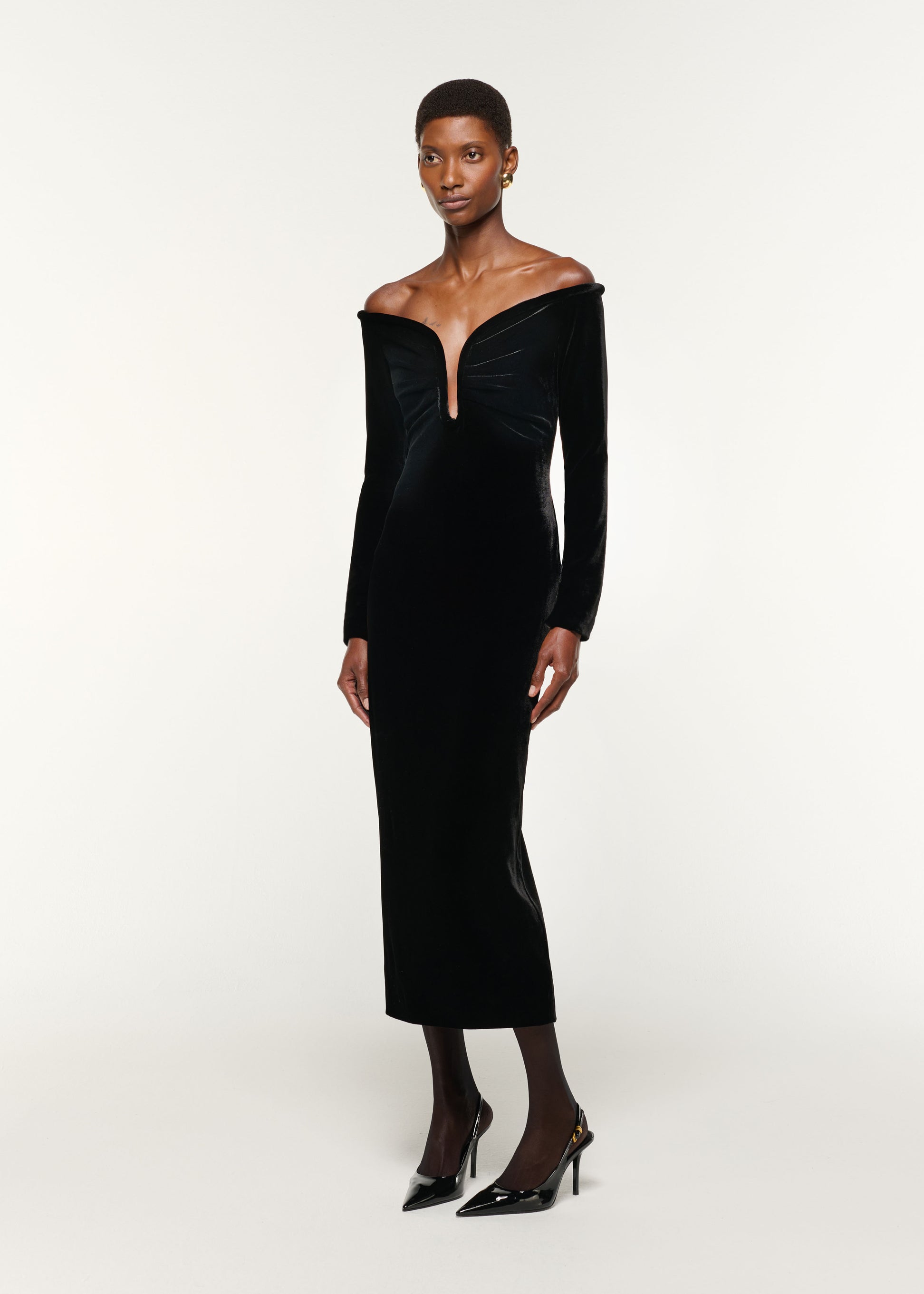 Side view of a model wearing the Plunge Neck Velvet Midi Dress in Black