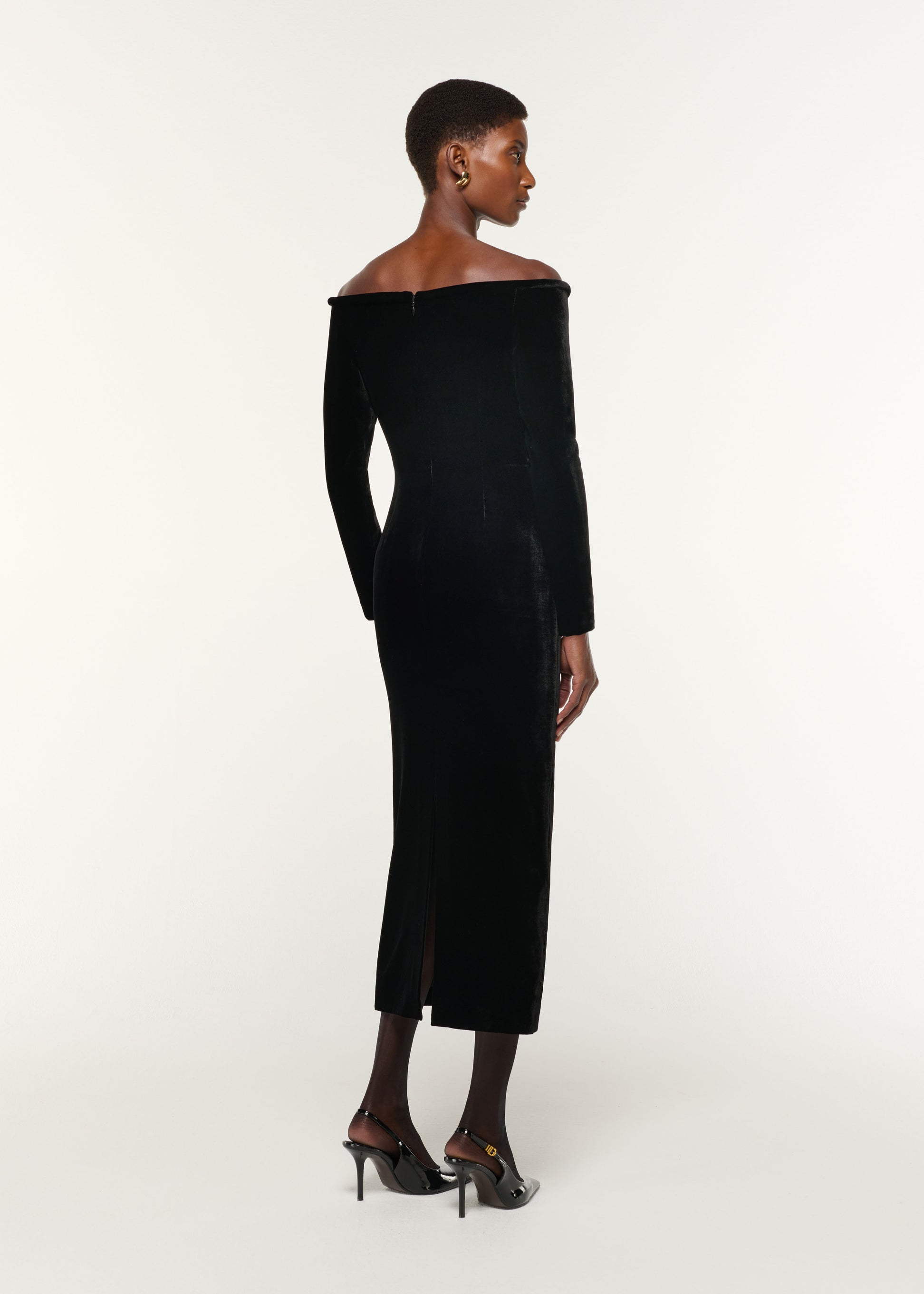 Back view of a model wearing the Plunge Neck Velvet Midi Dress in Black