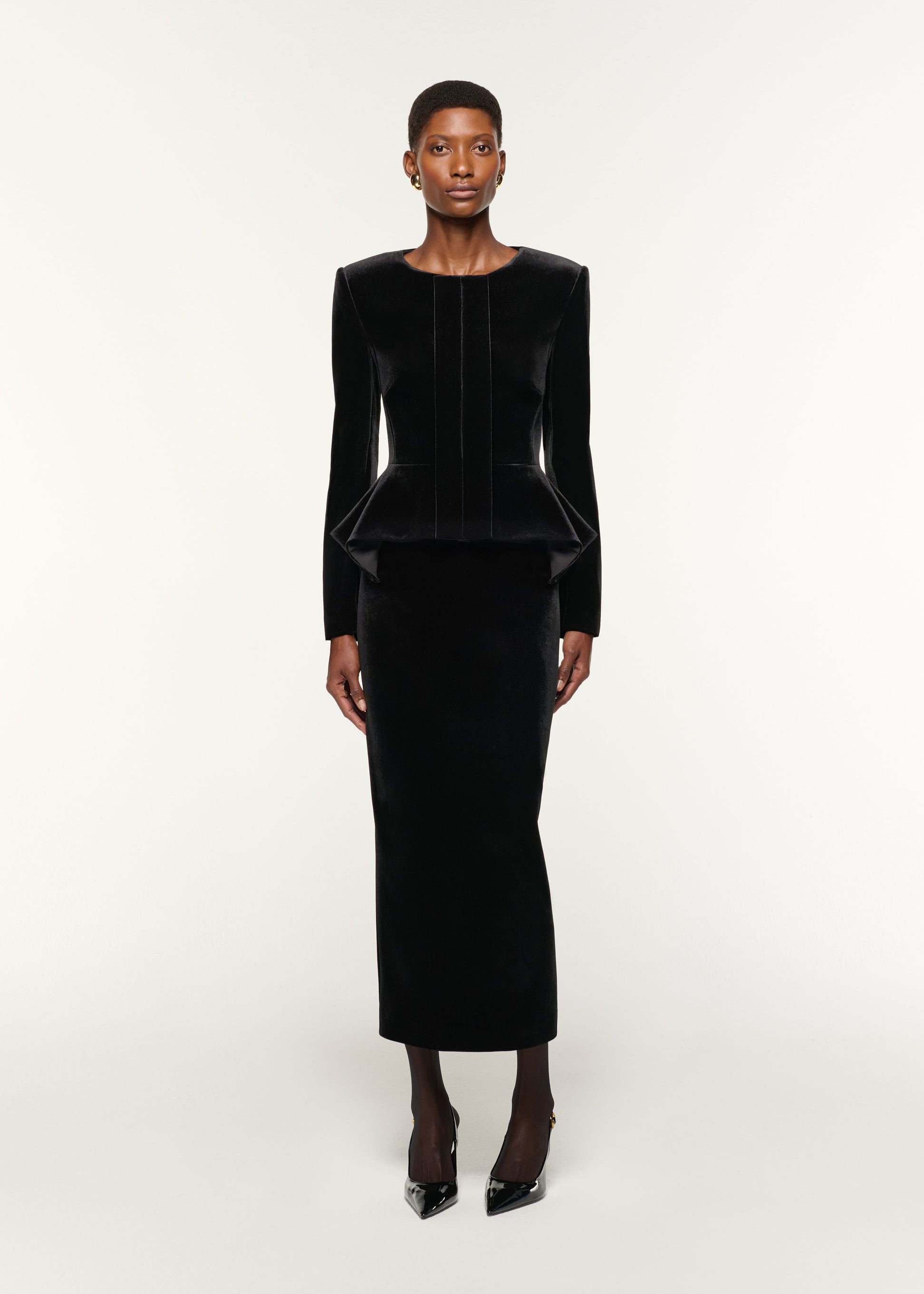 Front view of a model wearing the Velvet Peplum Jacket in Black