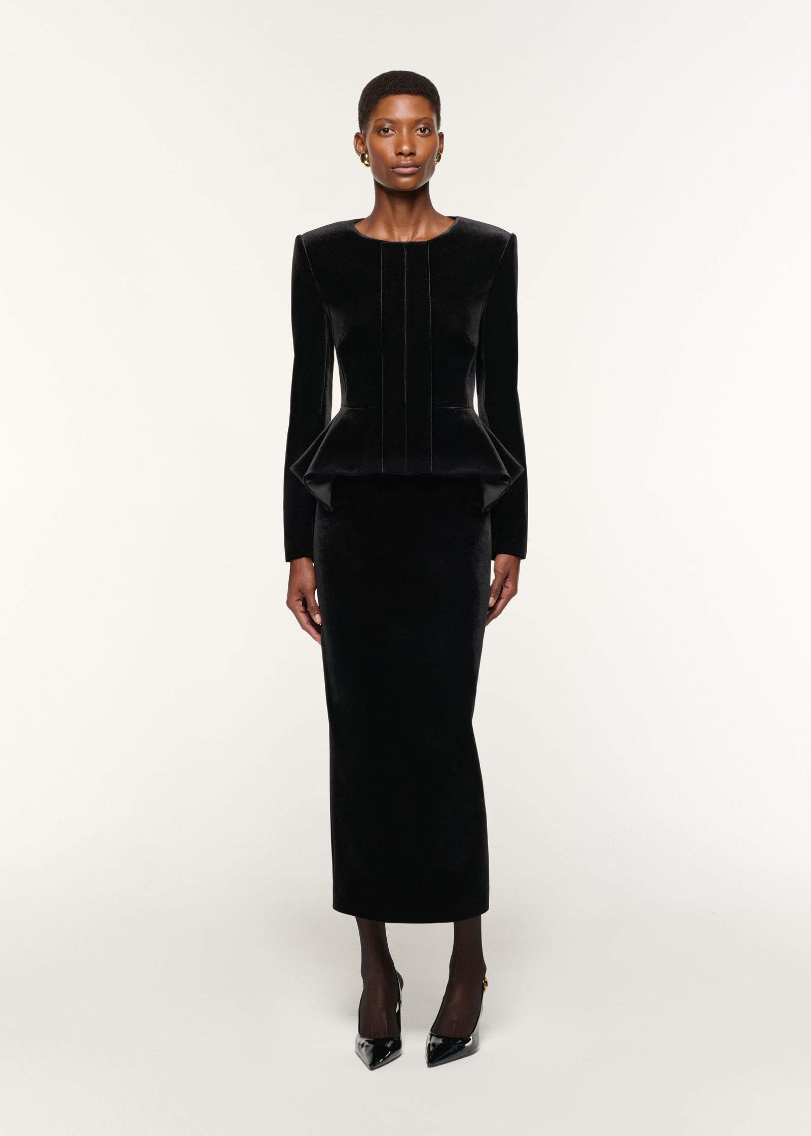 Front view of a model wearing the Velvet Midi Skirt in Black