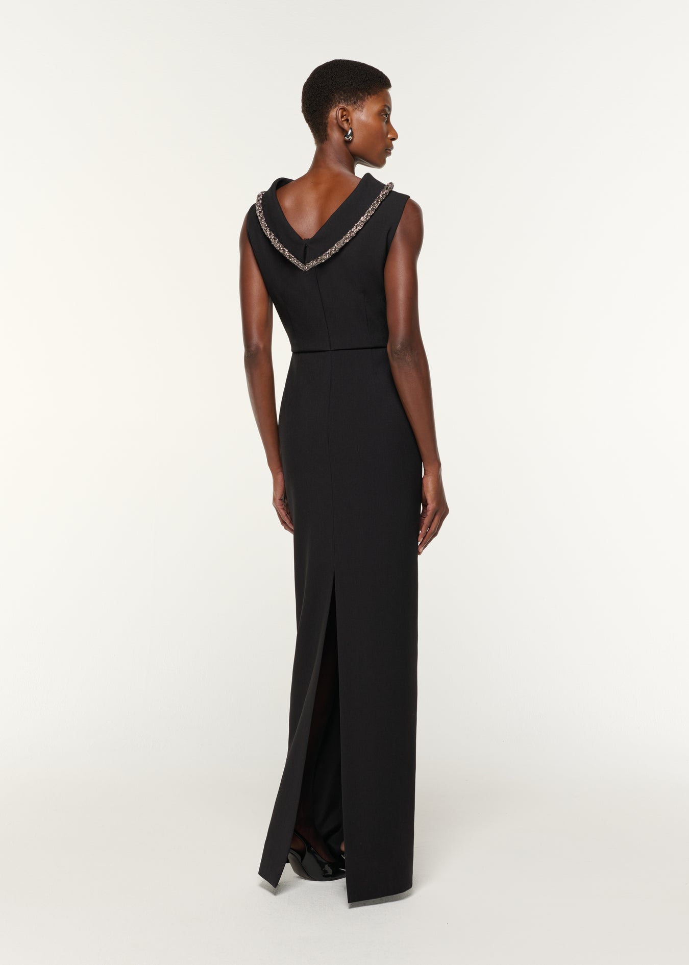 Back view of a model wearing the Diamante Roll Neck Crepe Gown in Black