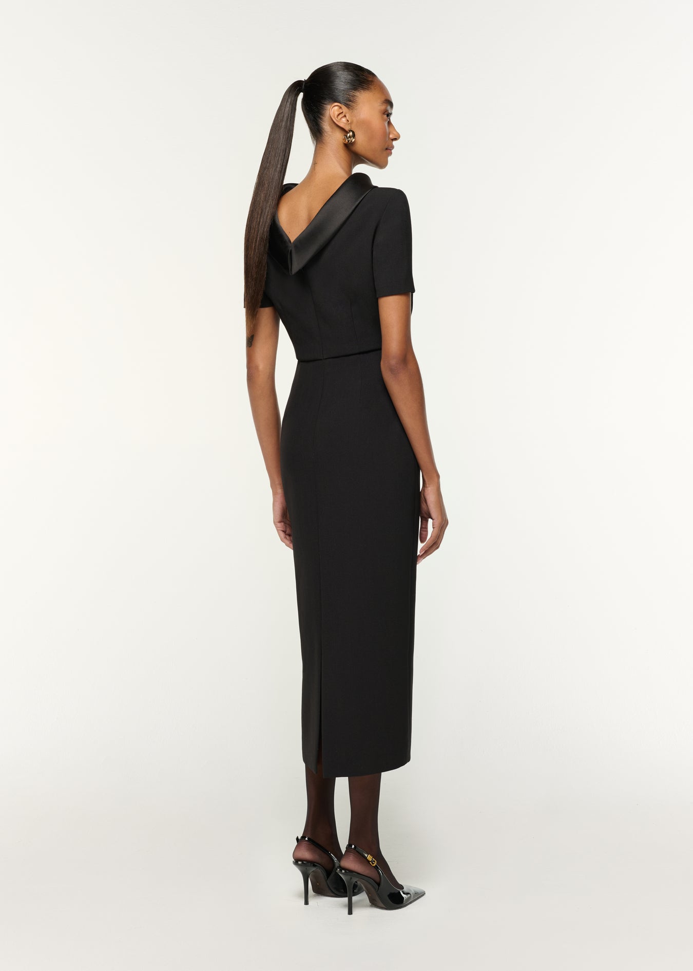 Back view of a model wearing the Collared Crepe Midi Dress in Black