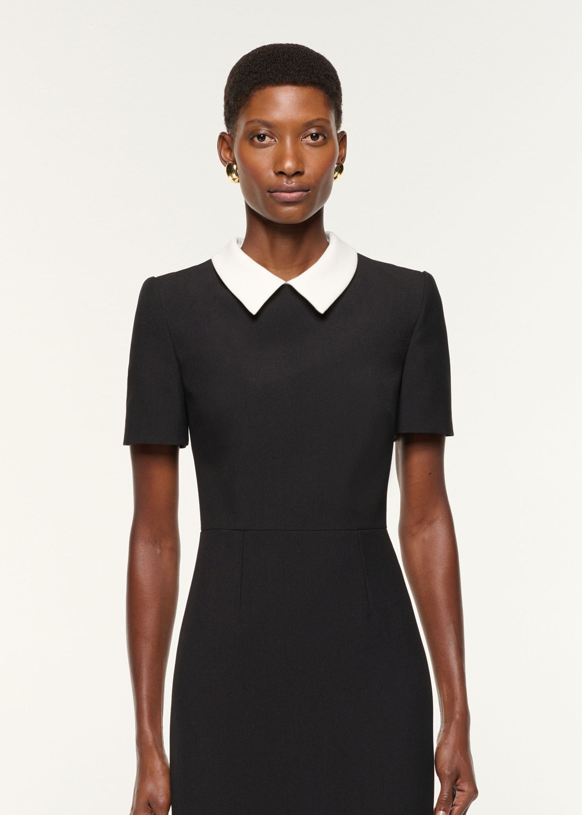 Close up of a model wearing the Contrast Collar Crepe Midi Dress in Black