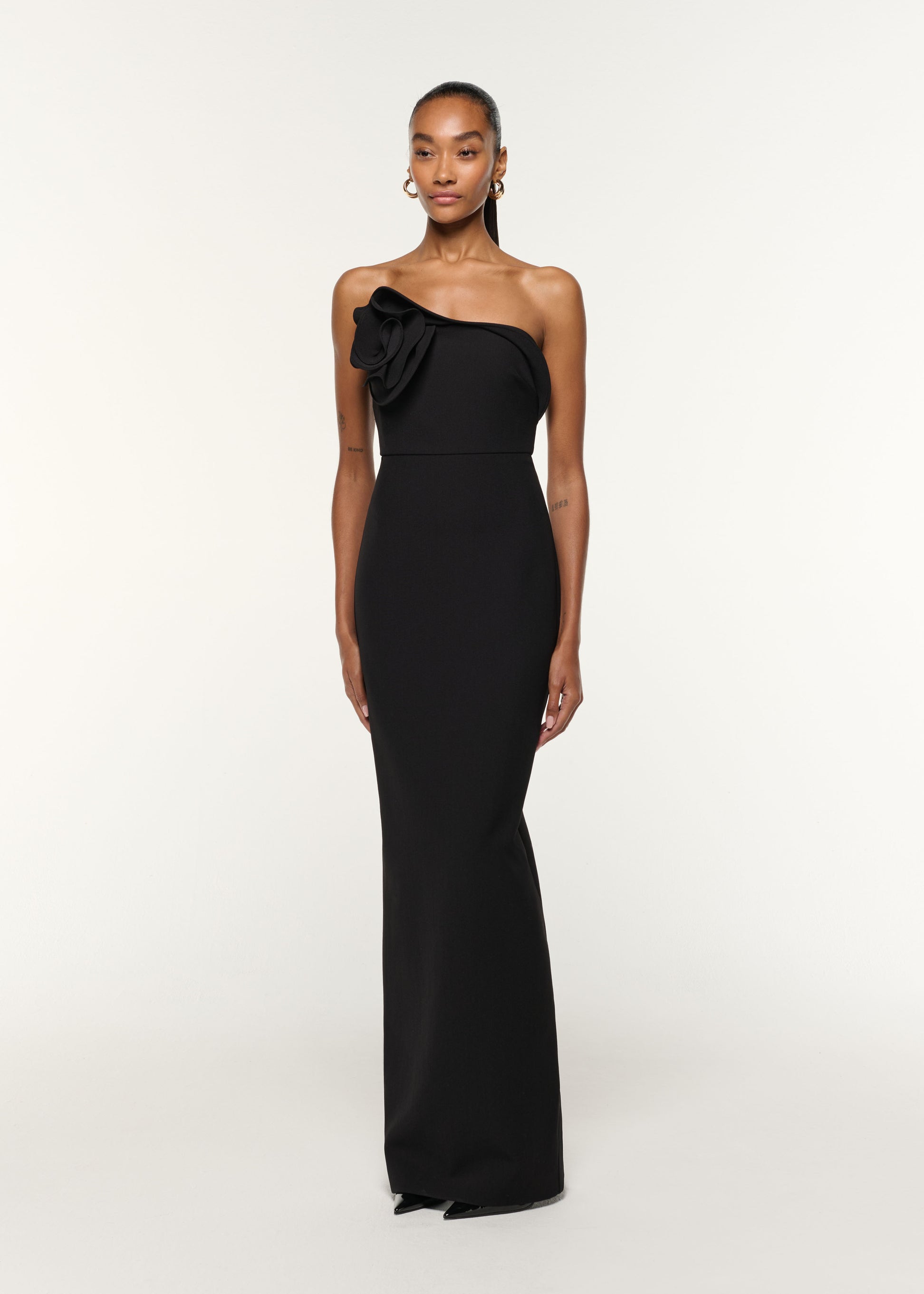 Side view of a model wearing the Flower Detail Strapless Gown in Black