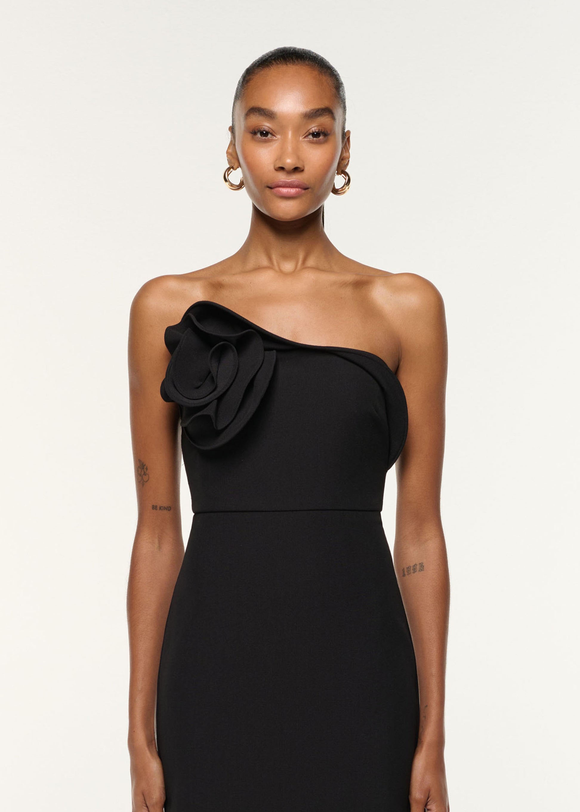 Close up of a model wearing the Flower Detail Strapless Gown in Black