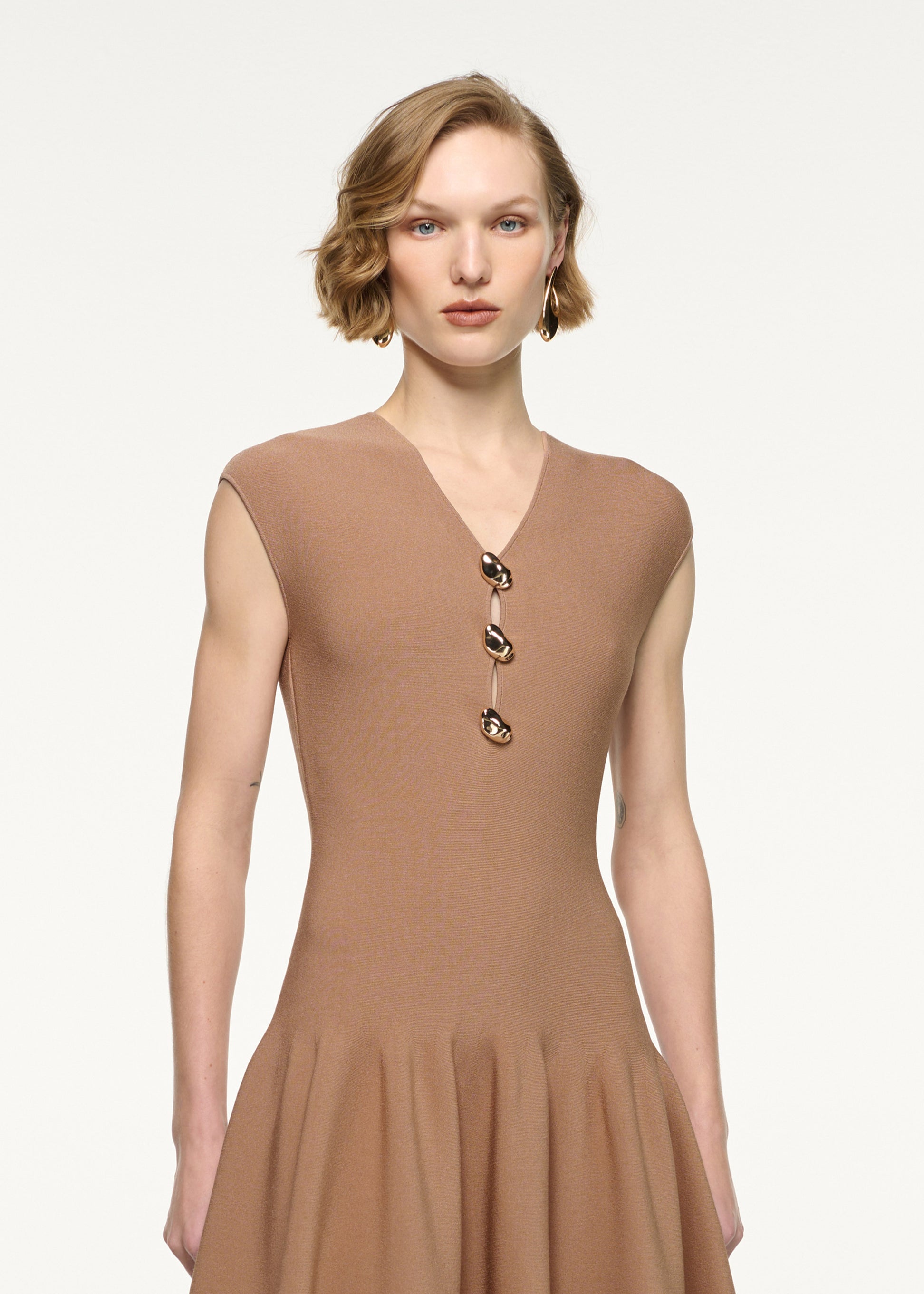 Close up of a model wearing the Pebble Trimmed Knit Dress in Camel