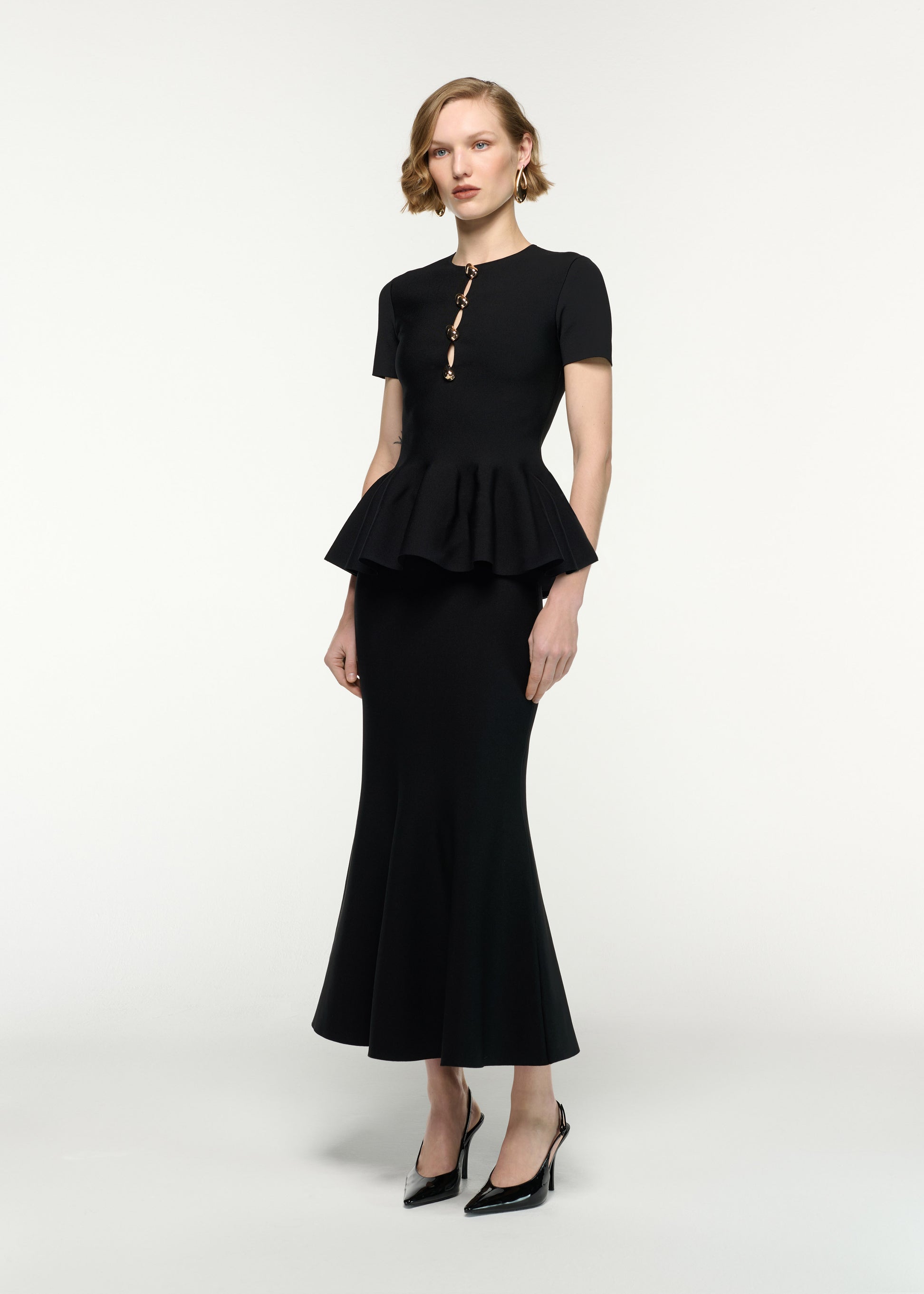 Side view of a model wearing the Pebble Trimmed Knit Top in Black