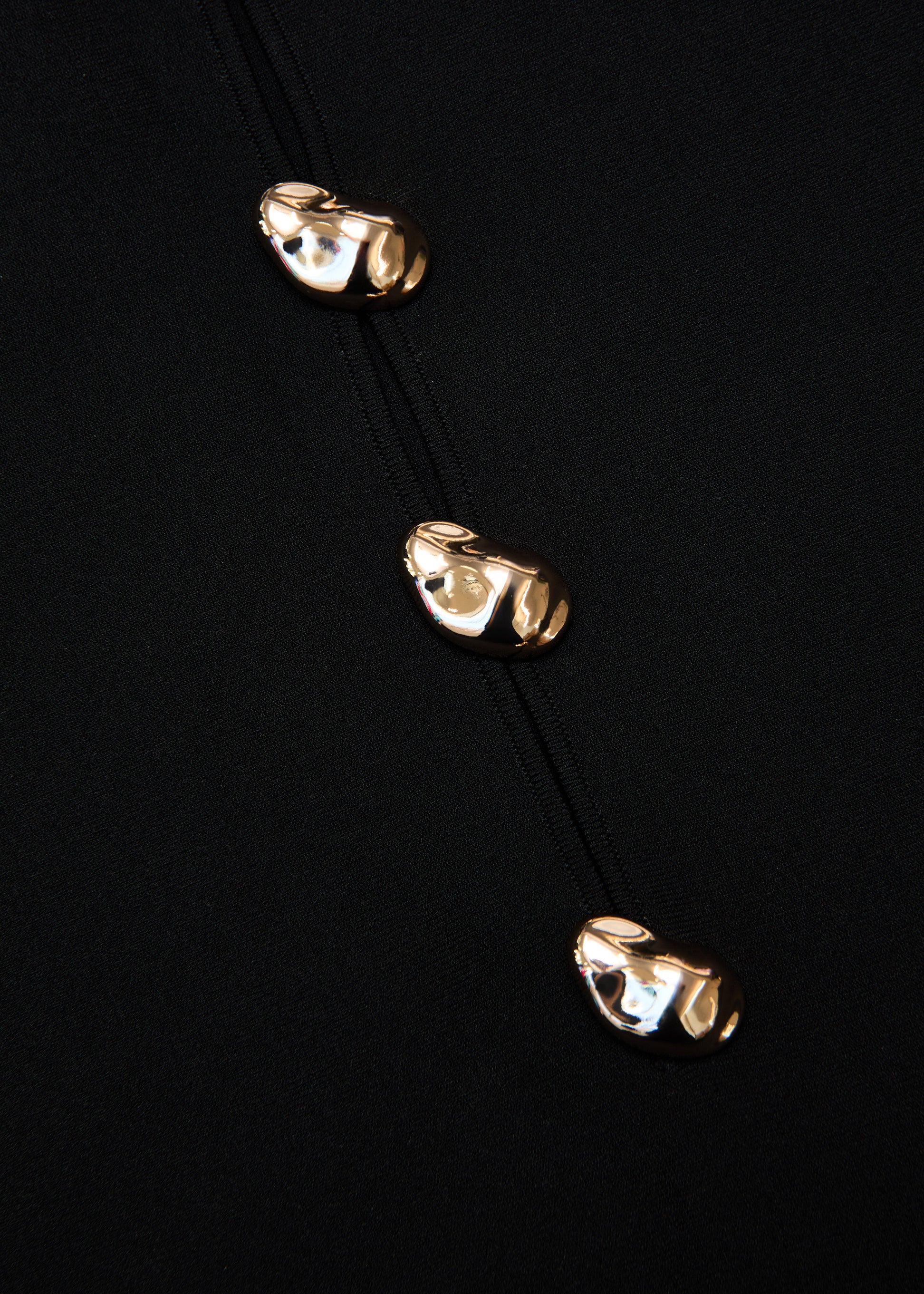 A close up of the fabric for the Pebble Trimmed Knit Top in Black