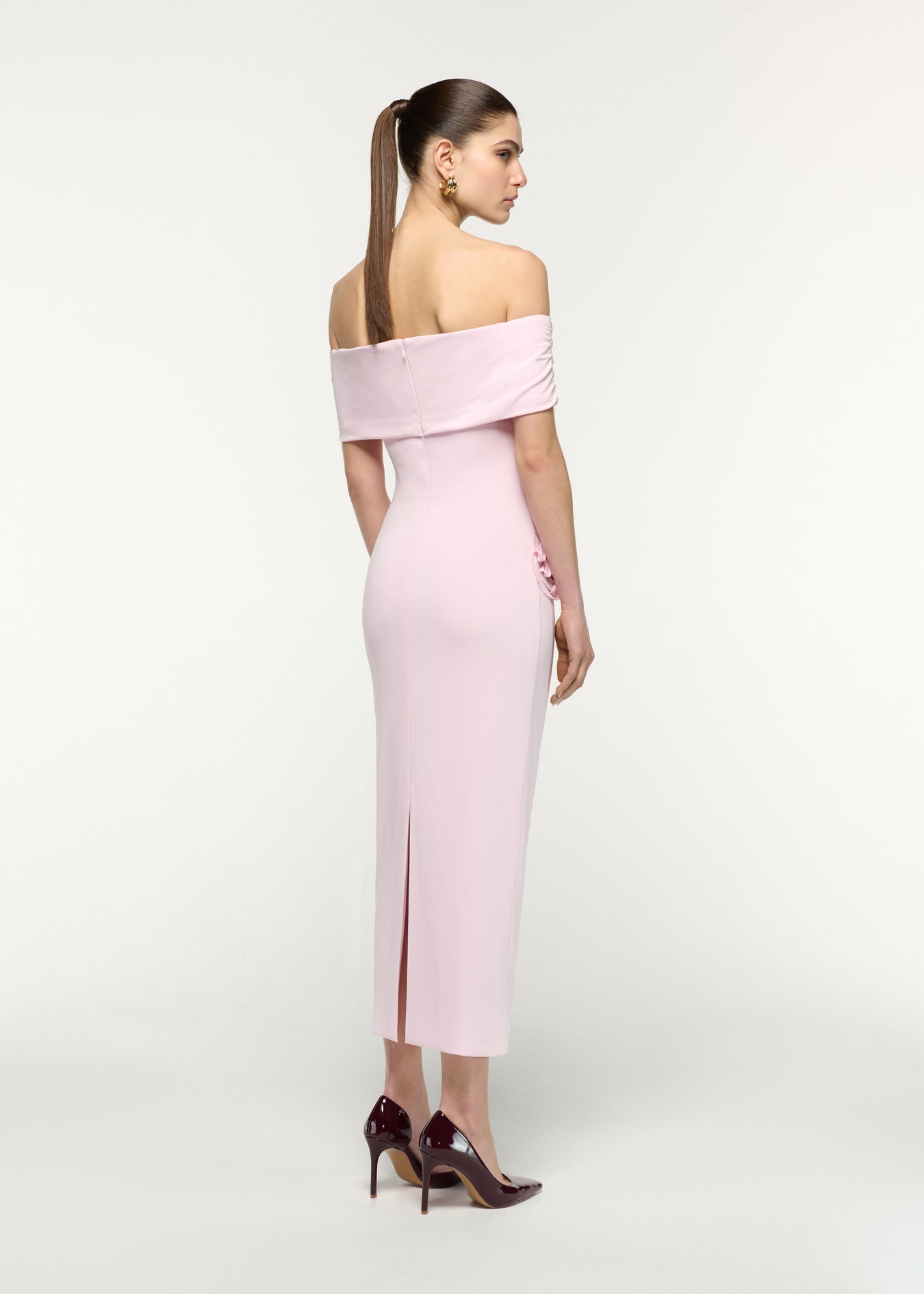 Back view of a model wearing the Off The Shoulder Flower Jersey Dress in Pink