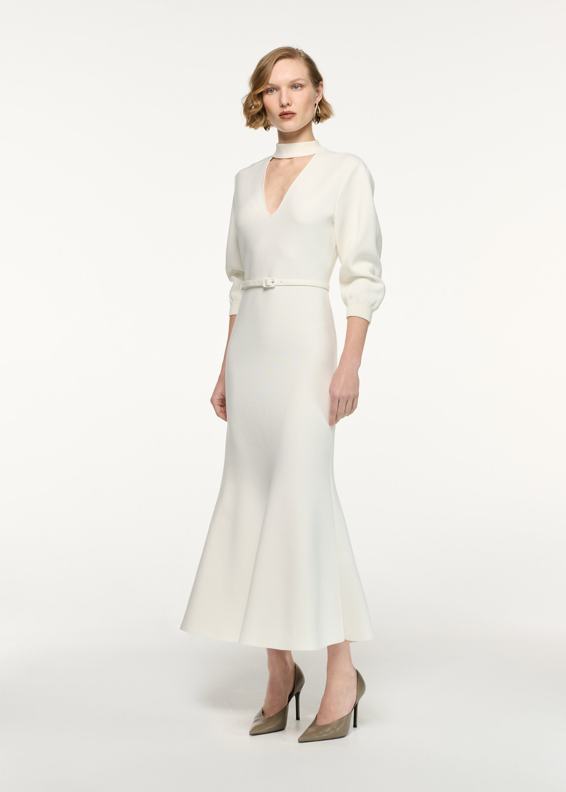 Side view of a model wearing the Belted Blouson Knit Midi Dress in Cream 