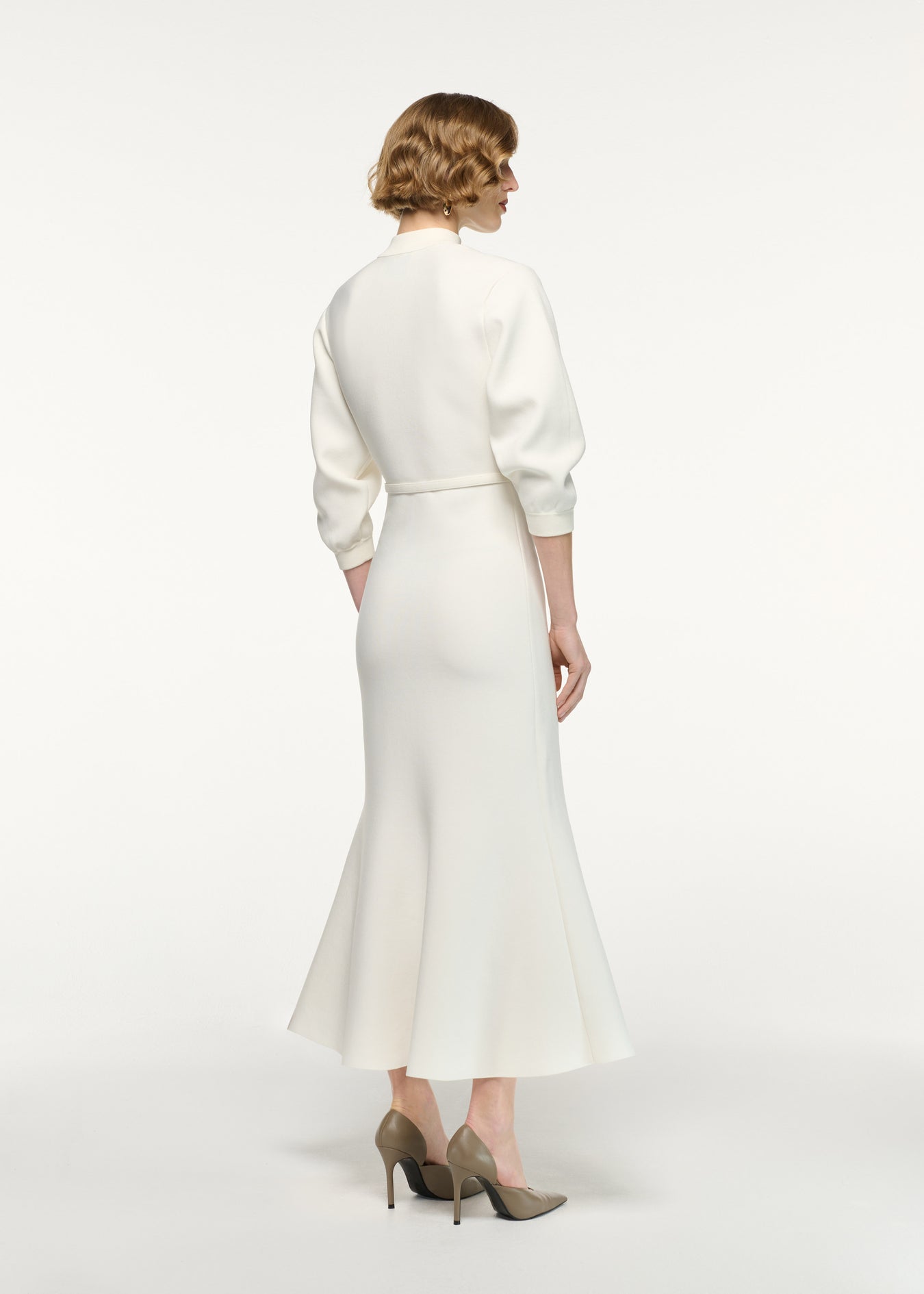 Back view of a model wearing the Belted Blouson Knit Midi Dress in Cream 