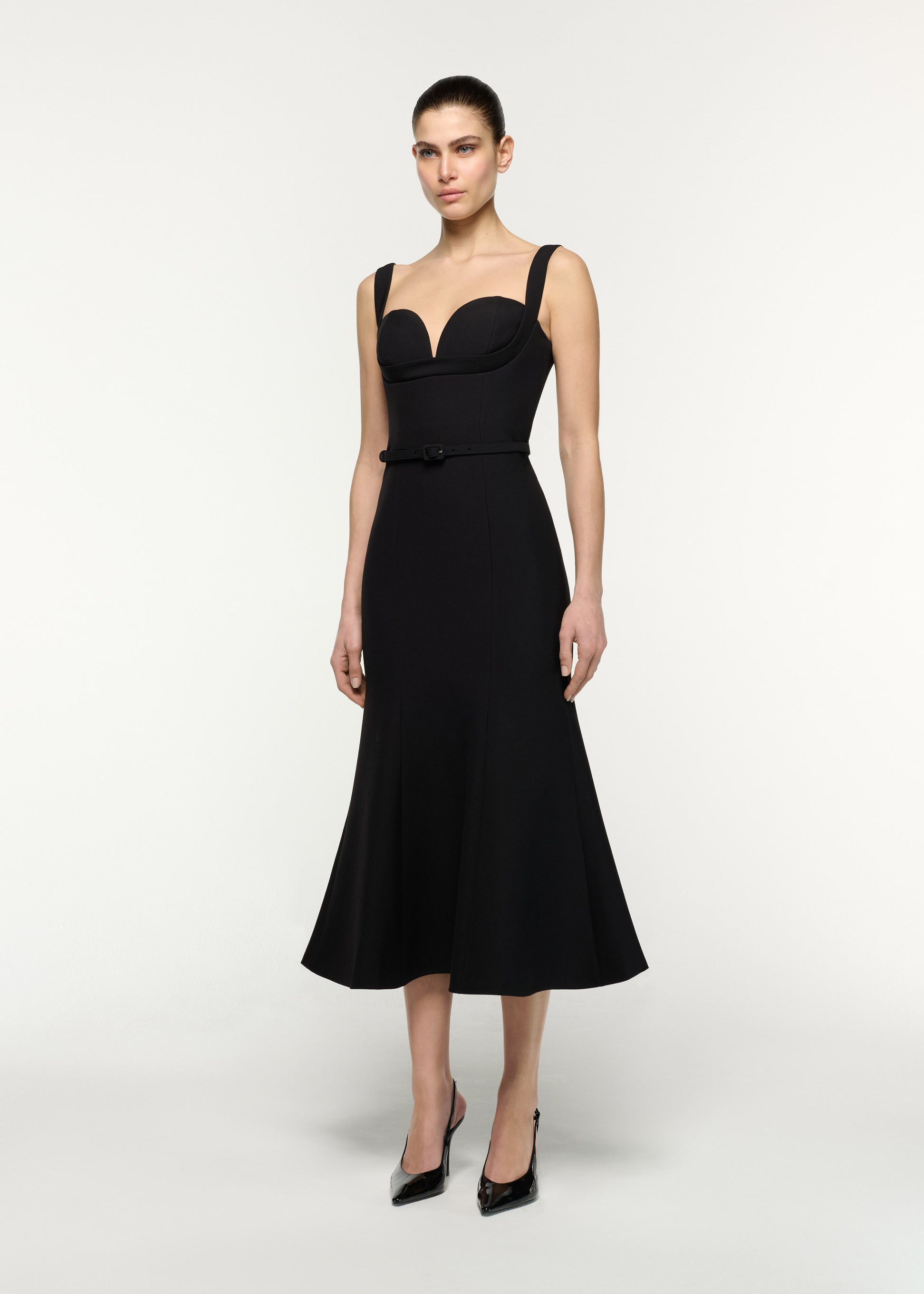 Side view of a model wearing the Belted Fit And Flare Midi Dress in Black 