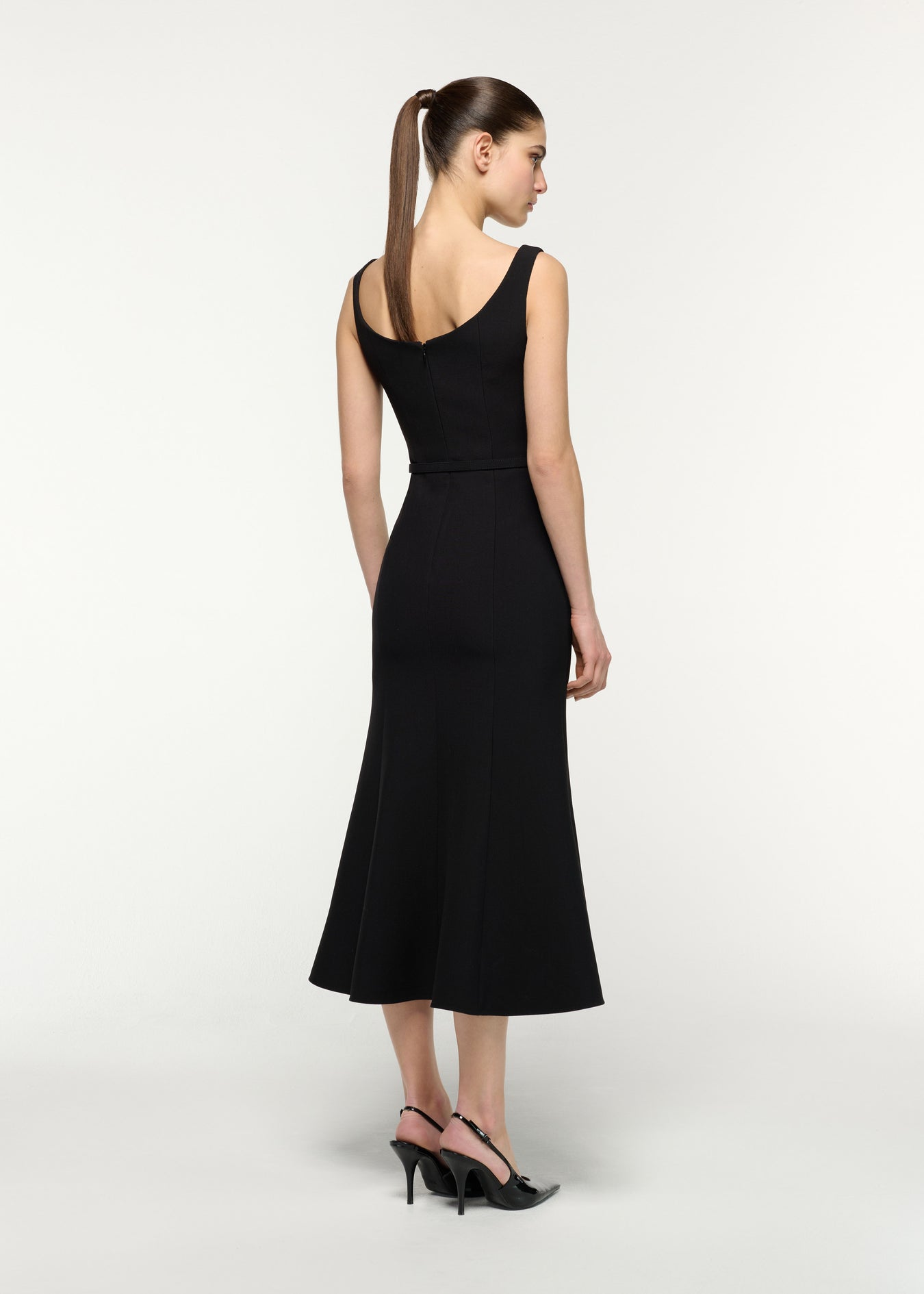 Back view of a model wearing the Belted Fit And Flare Midi Dress in Black 