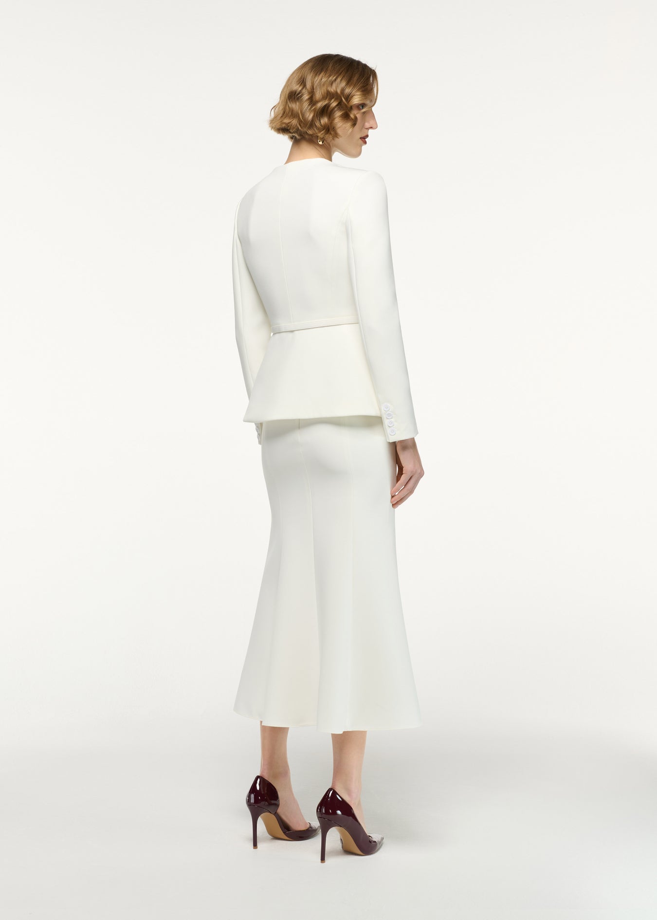 Back view of a model wearing the Fit And Flare Midi Skirt in Cream 