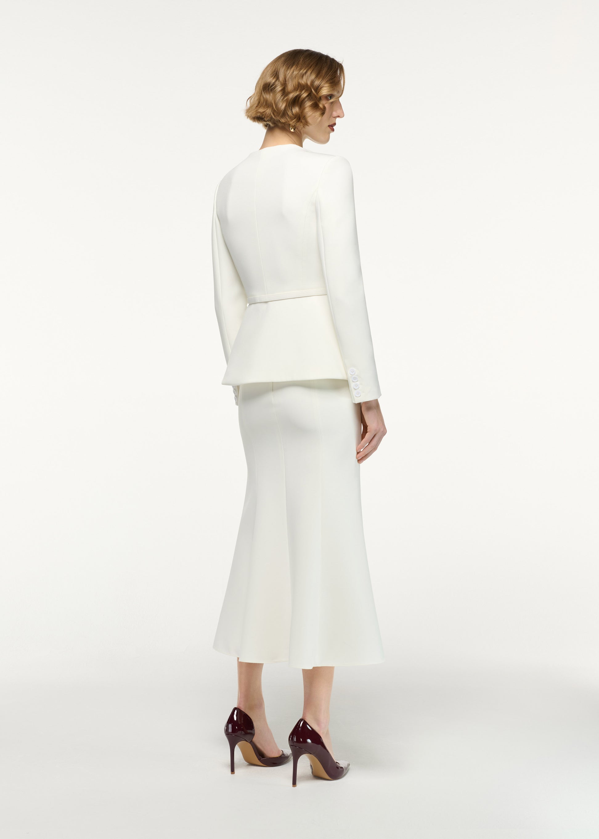 Back view of a model wearing the Fit And Flare Midi Skirt in Cream 