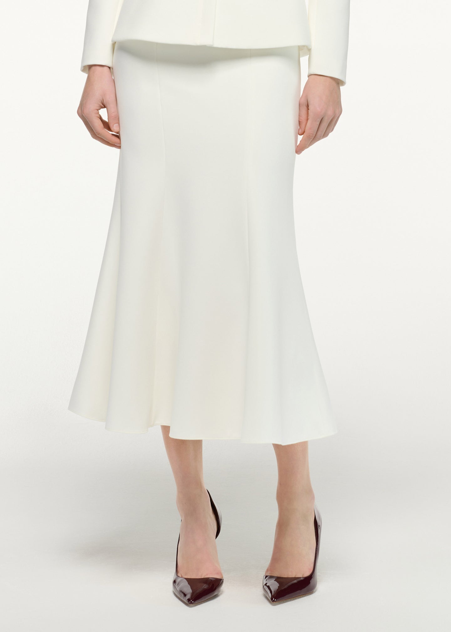 Close up of a model wearing the Fit And Flare Midi Skirt in Cream 