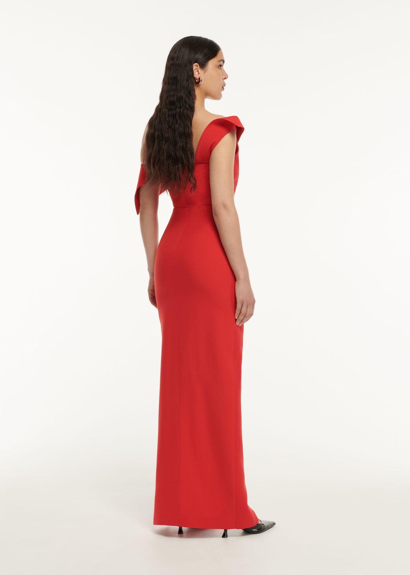The back of a woman wearing the Asymmetric Drape Wool Silk Maxi Dress