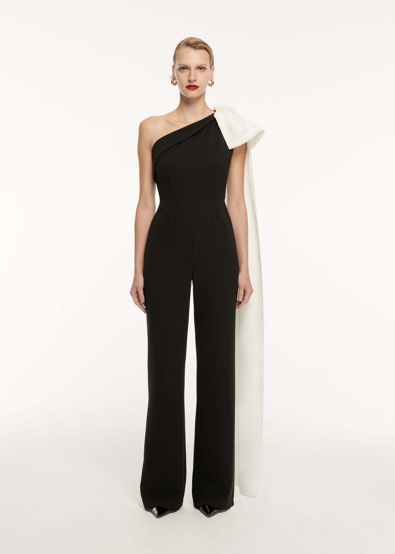 A woman wearing the Asymmetric Stretch Cady Jumpsuit in Monochrome