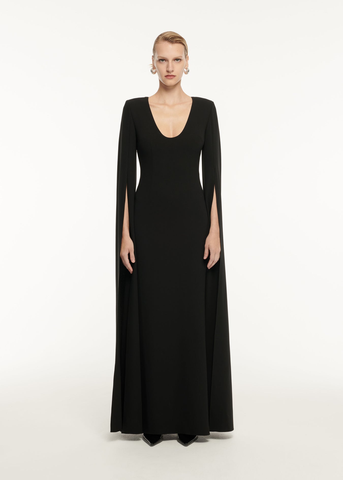 A woman wearing the Cape Sleeve Stretch Cady Maxi Dress in Black