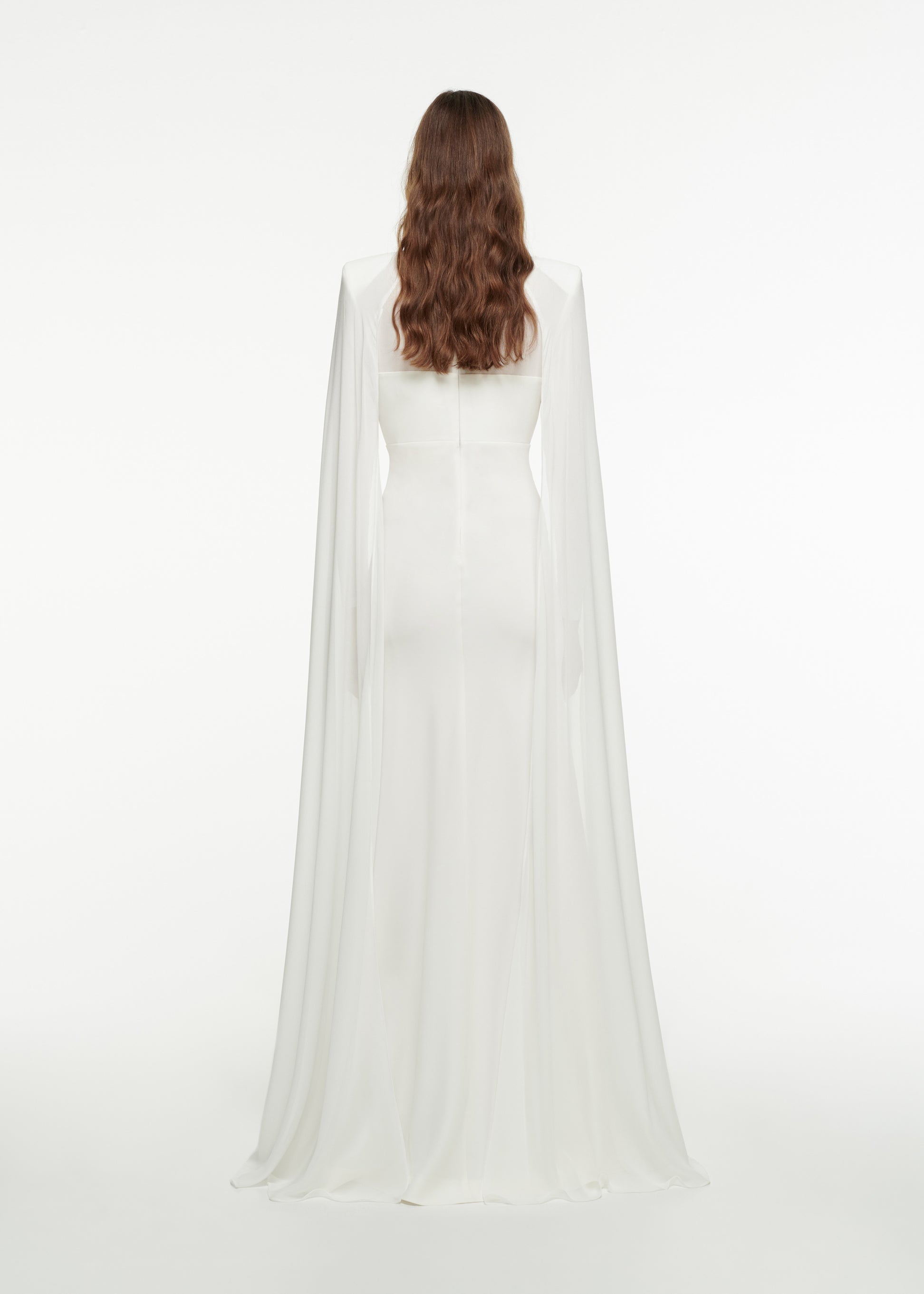 The back of a woman wearing the Long Sleeve Cape Gown in White 