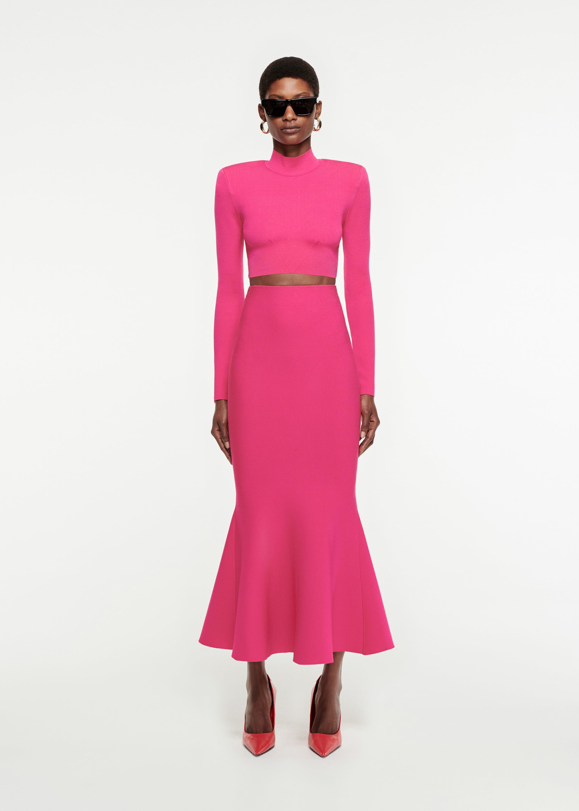 Woman wearing the Fluted Knit Midi Skirt in Pink