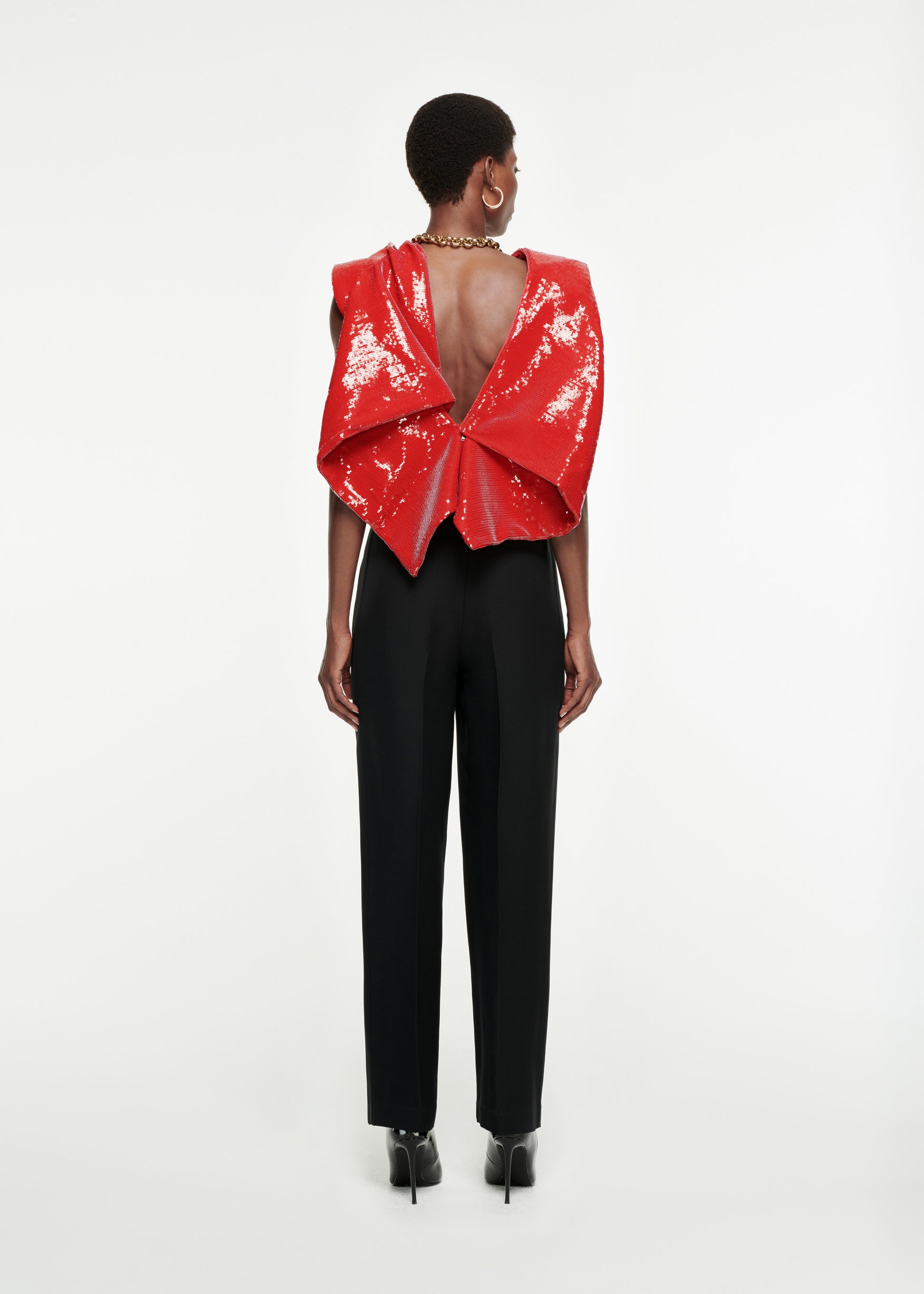 The back of a woman wearing the Draped Sequin Top in Red