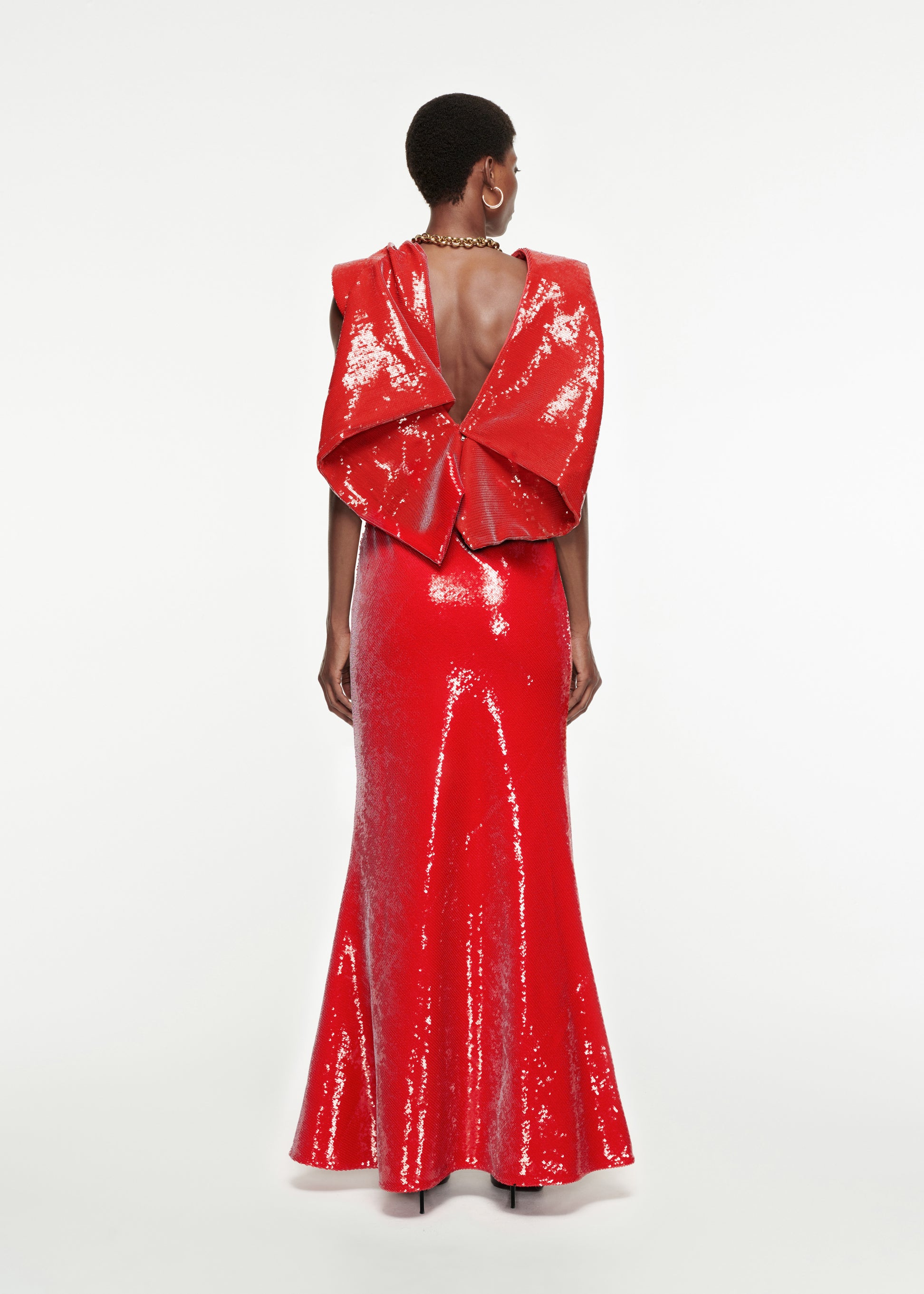 The back of a woman wearing the Draped Sequin Gown in Red