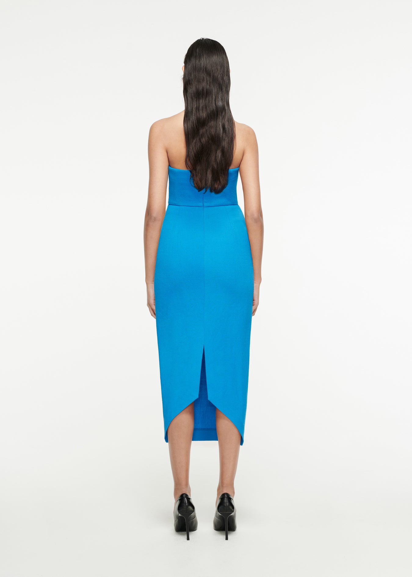 The back of a woman wearing the Strapless Origami Midi Dress in Blue
