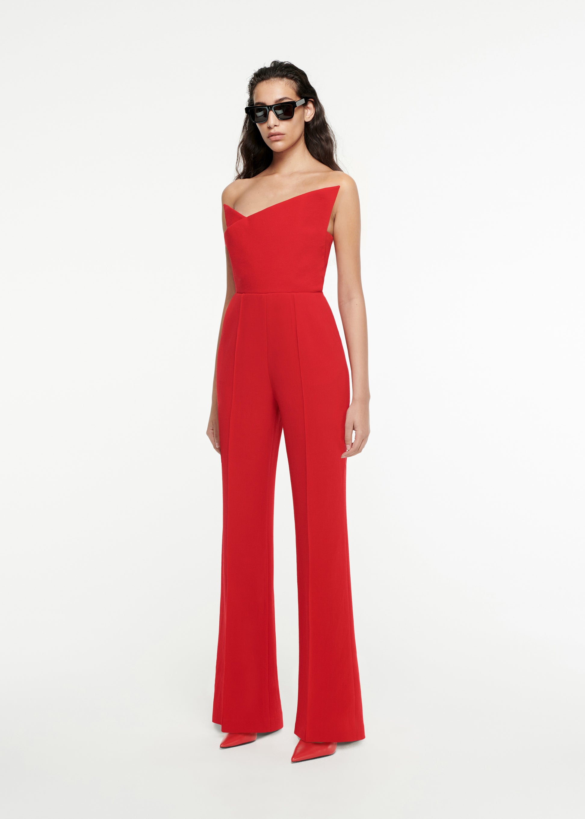 Woman wearing the Asymmetric Wool Crepe Jumpsuit in Red