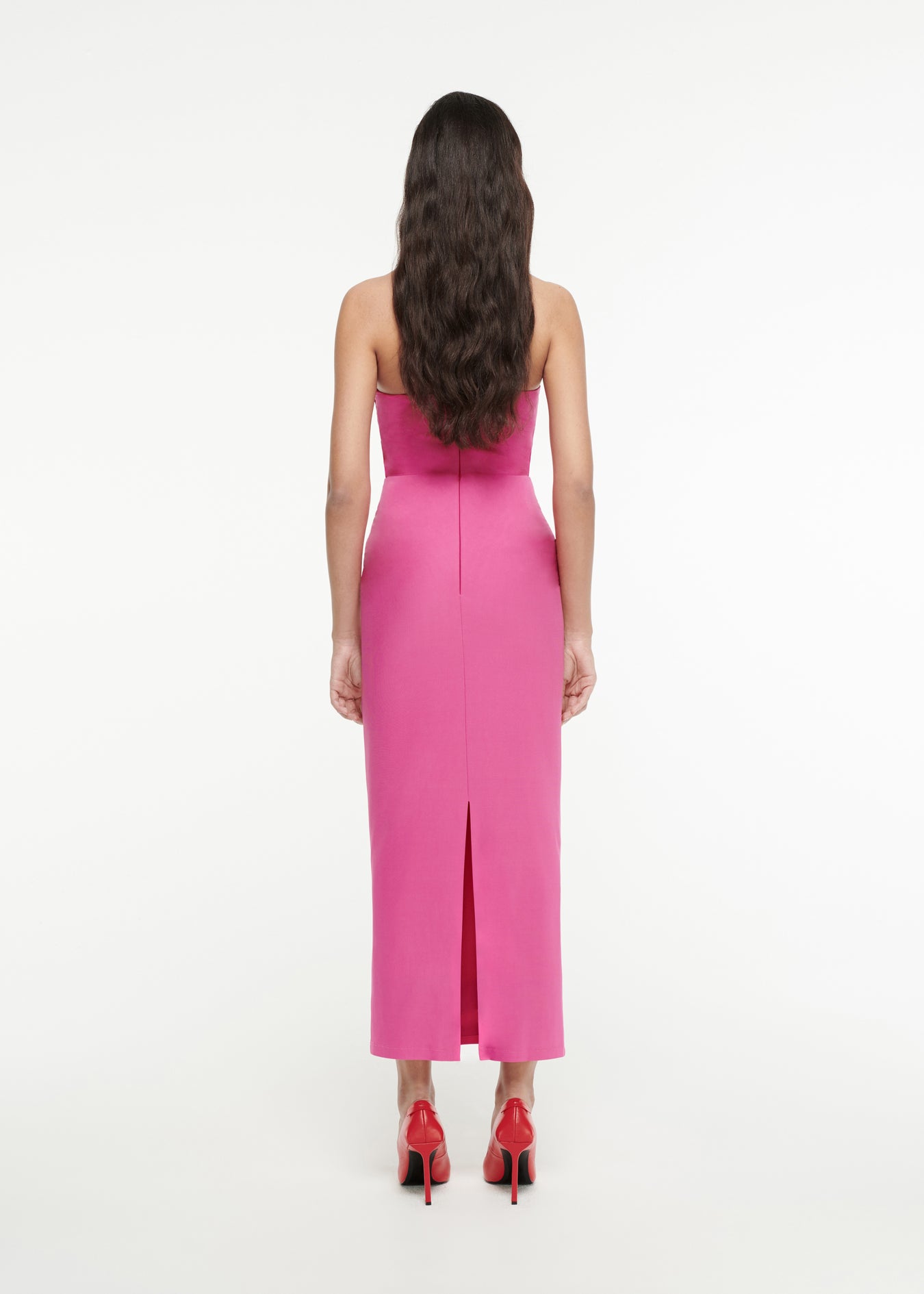 The back of a woman wearing the Asymmetric Silk Wool Midi Dress in Pink