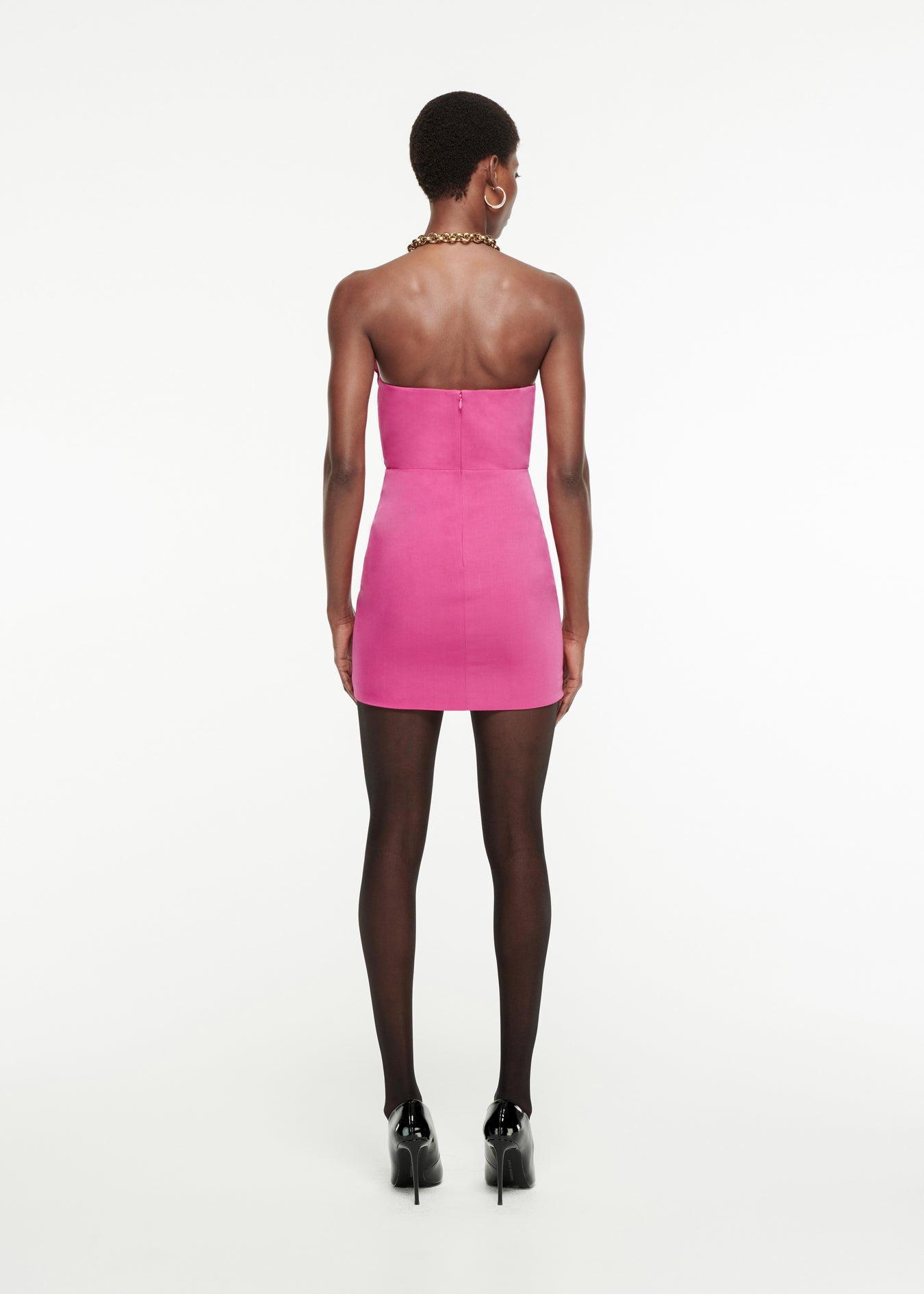The back of a woman wearing the Asymmetric Silk Wool Mini Dress in Pink 