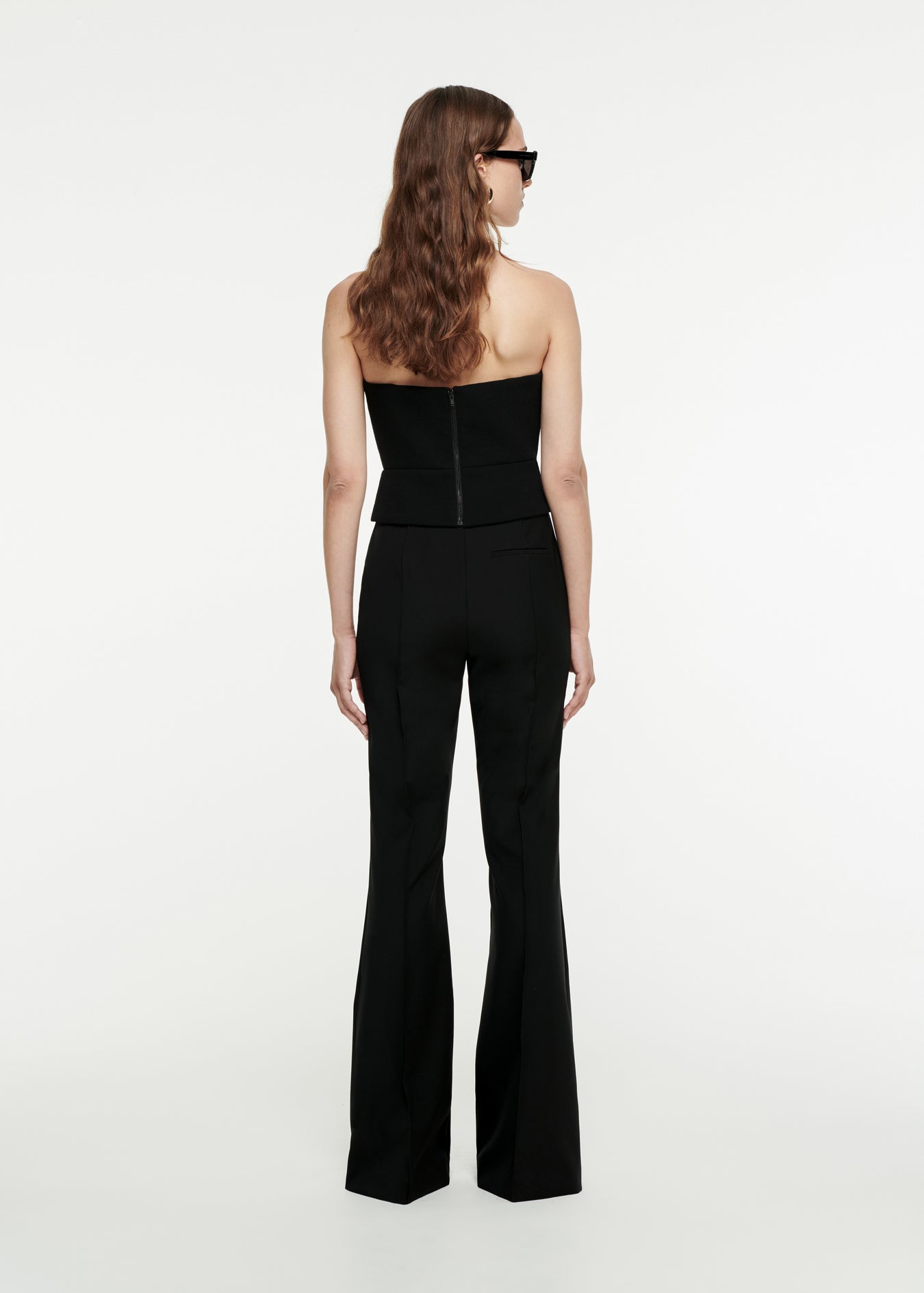 The back of a woman wearing the Asymmetric Wool Crepe Top in Black 